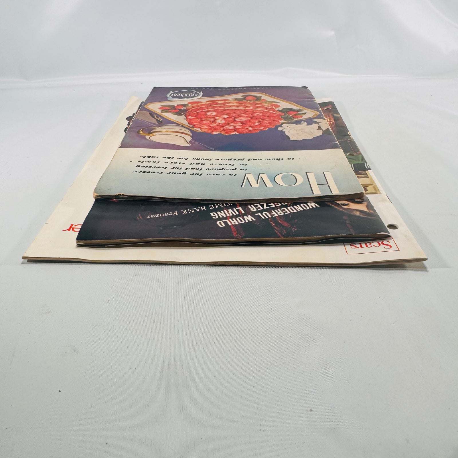 Three Sears Coldspot manuals stacked from the other side