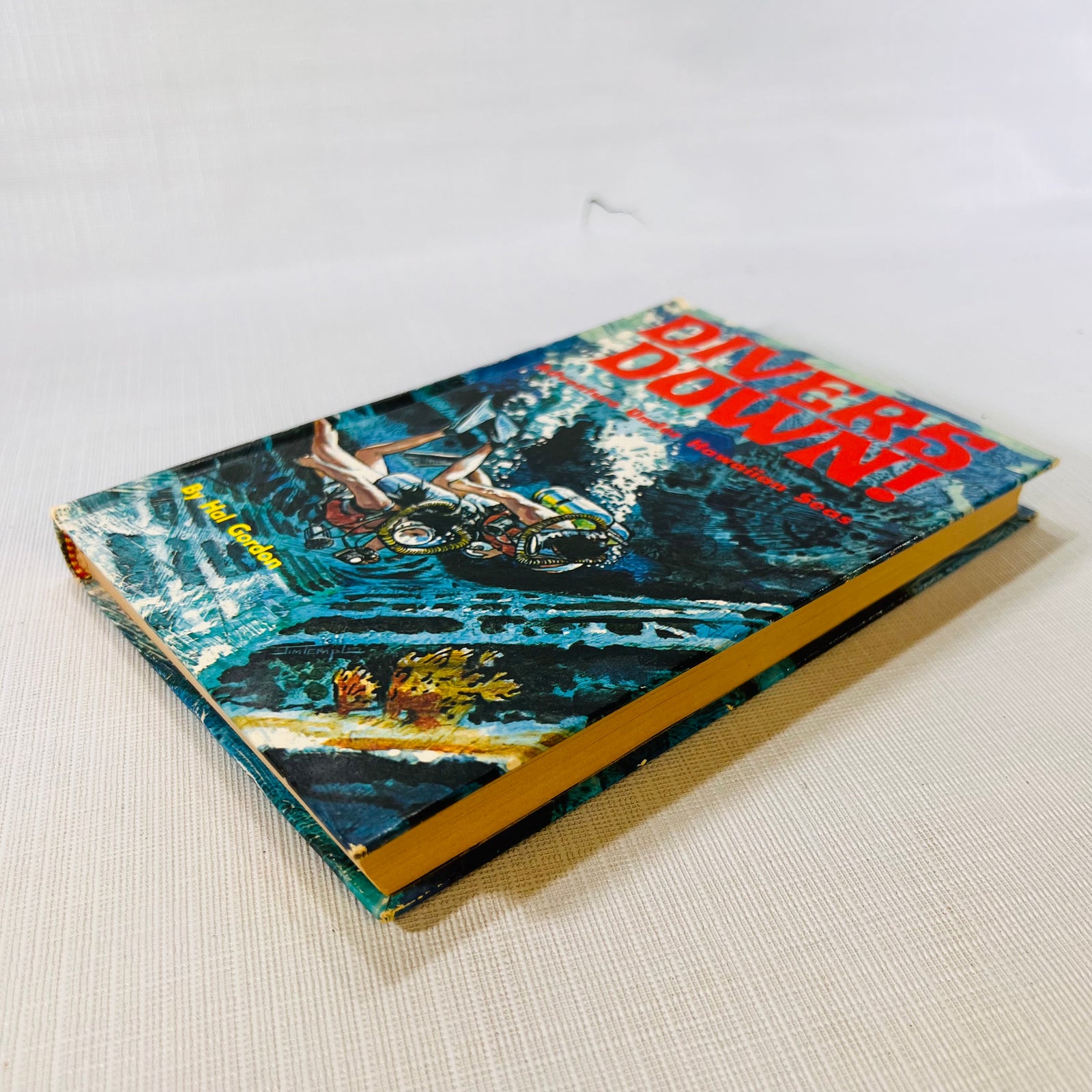 Divers Down! 1971 hardcover lying at an angle, showing the cover and page edges