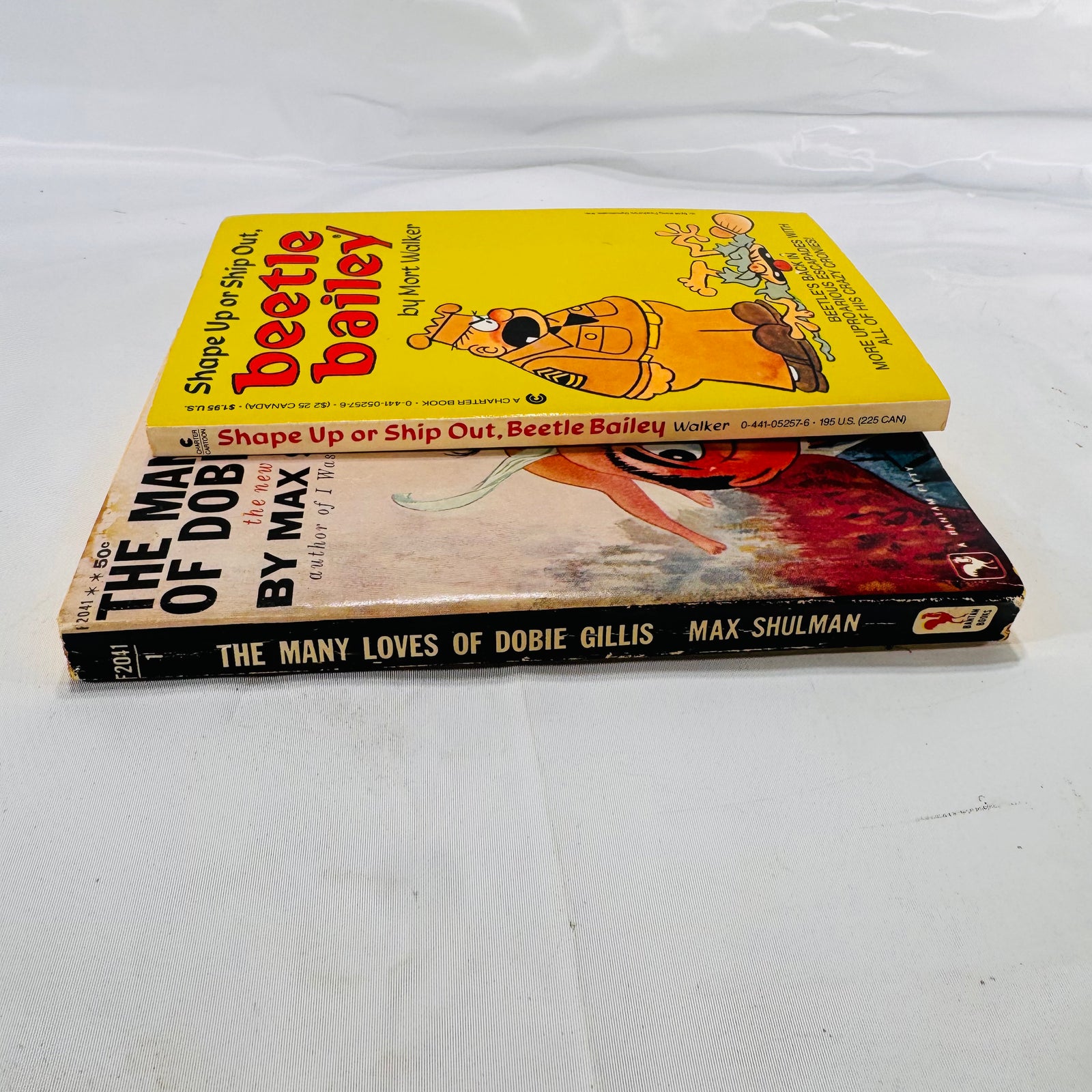 Shape Up or Ship Out by Mort Walker (1985) & The Many Loves of Dobie Gillis by Max Shulman (1951), Paperback Bundle