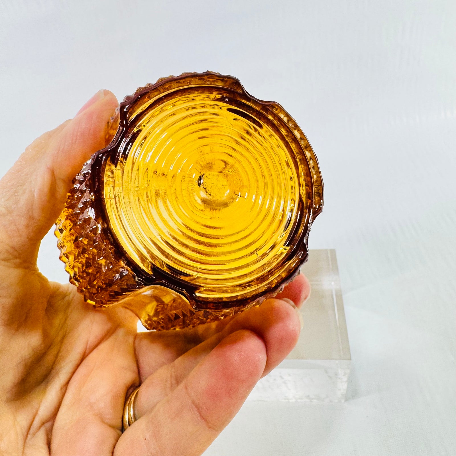 Scalloped rim and concentric ring pattern inside an amber glass light shade