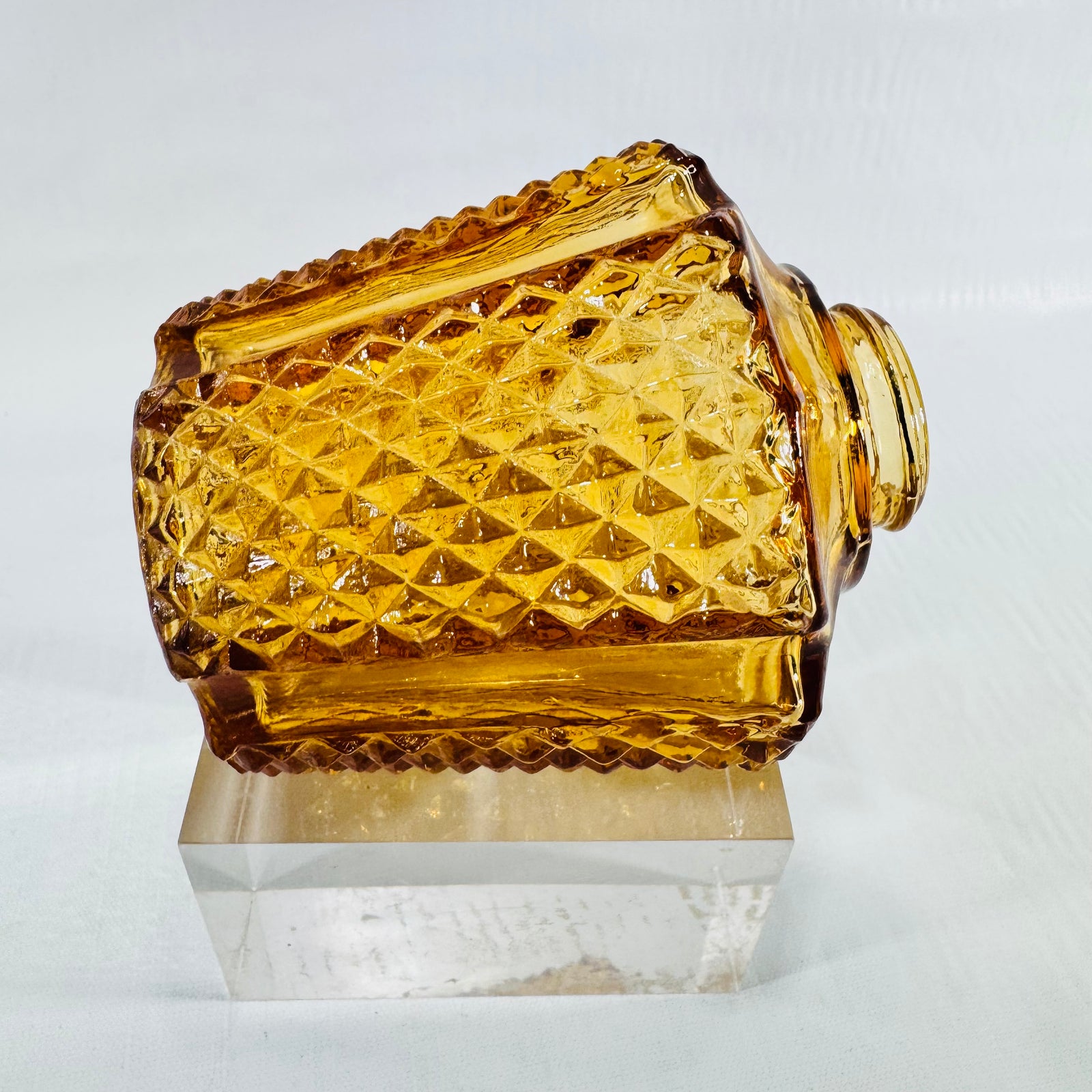 Amber diamond point glass shade lying on its side showing the pattern and neck