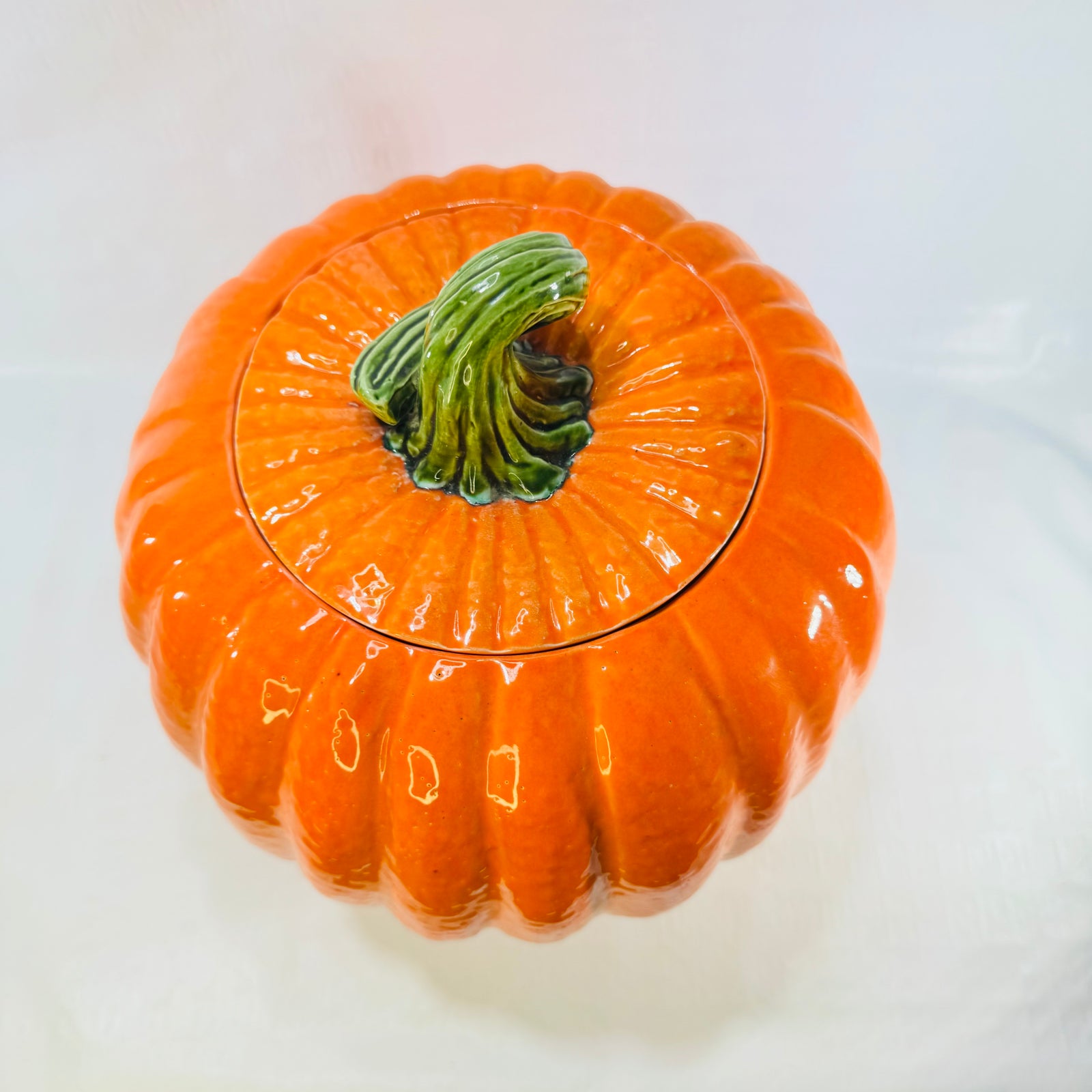 Top view of the ceramic pumpkin jar lid with curled green stem