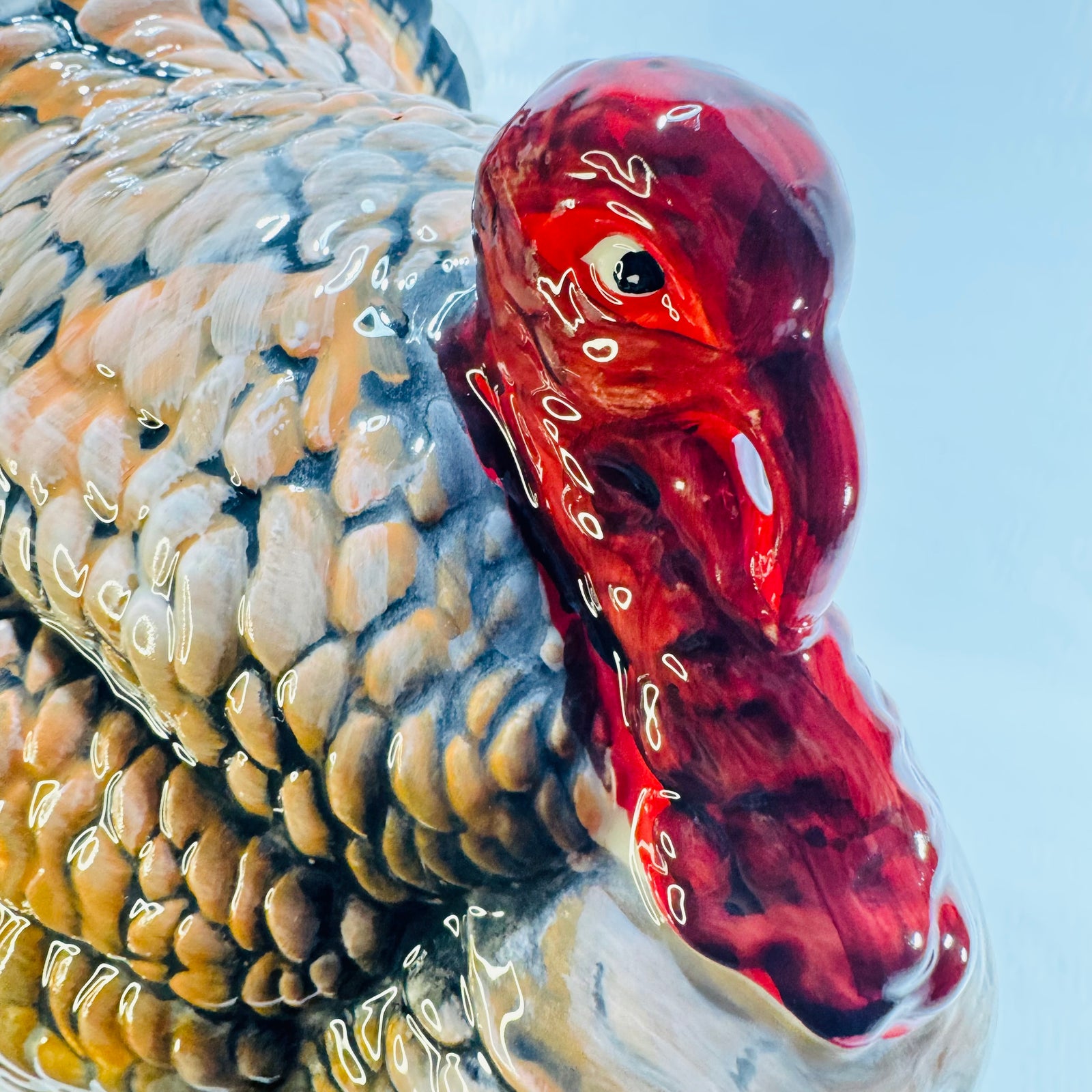 Close up of the red head and wattle on a glazed ceramic turkey figurine
