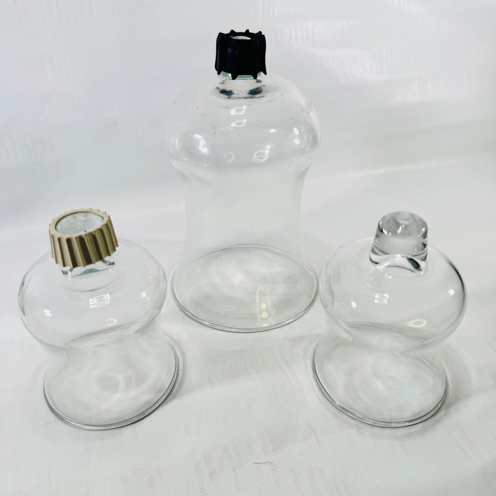 All three peg votive cups upside down, showing the tan gripper, black gripper, and bare peg.