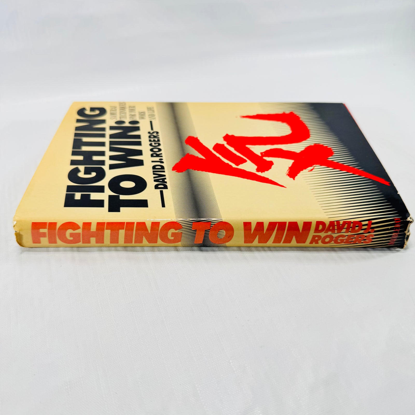 Spine of the Fighting to Win dust jacket showing title, author, and edge wear at the ends.
