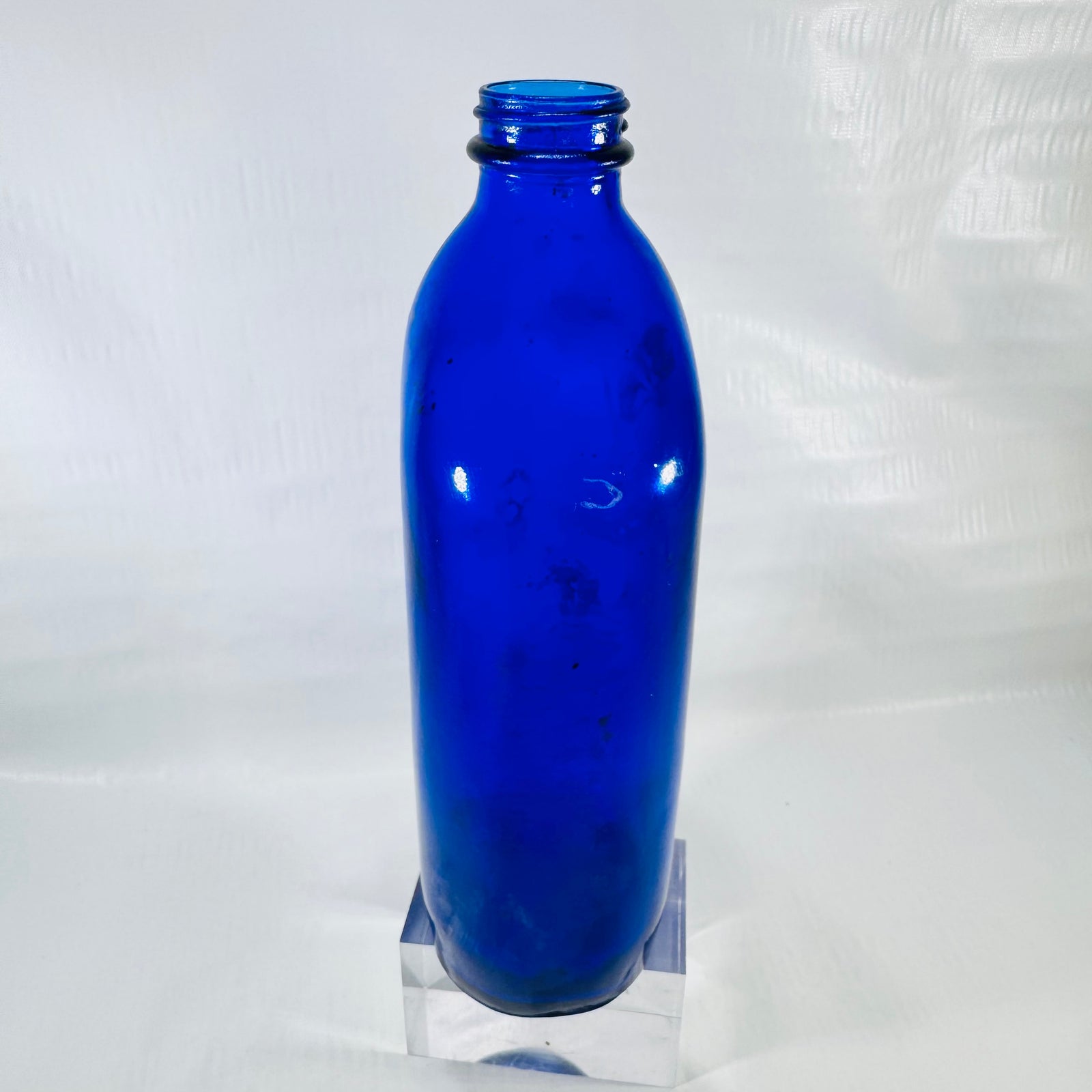Side view of the cobalt blue Phillips bottle showing its rounded shape and residue inside.