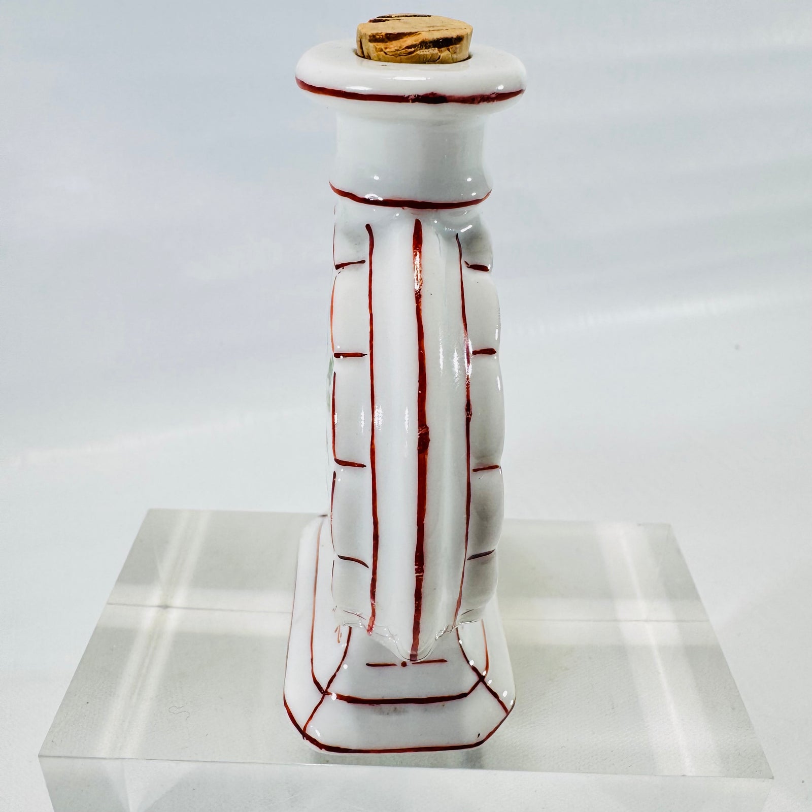 Other side view of the porcelain moon flask bottle with red trim lines and cork stopper.