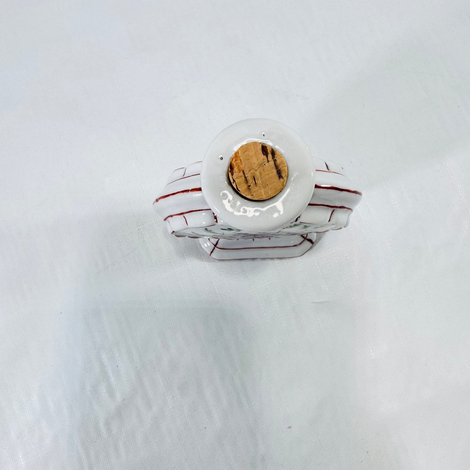 Top view of the porcelain moon flask bottle rim with the dried, cracked cork stopper.