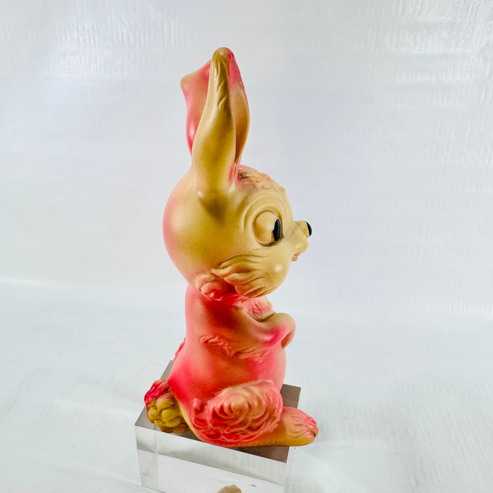 Right side profile of the rabbit showing the long upright ear, black eye, and molded cheek fur.