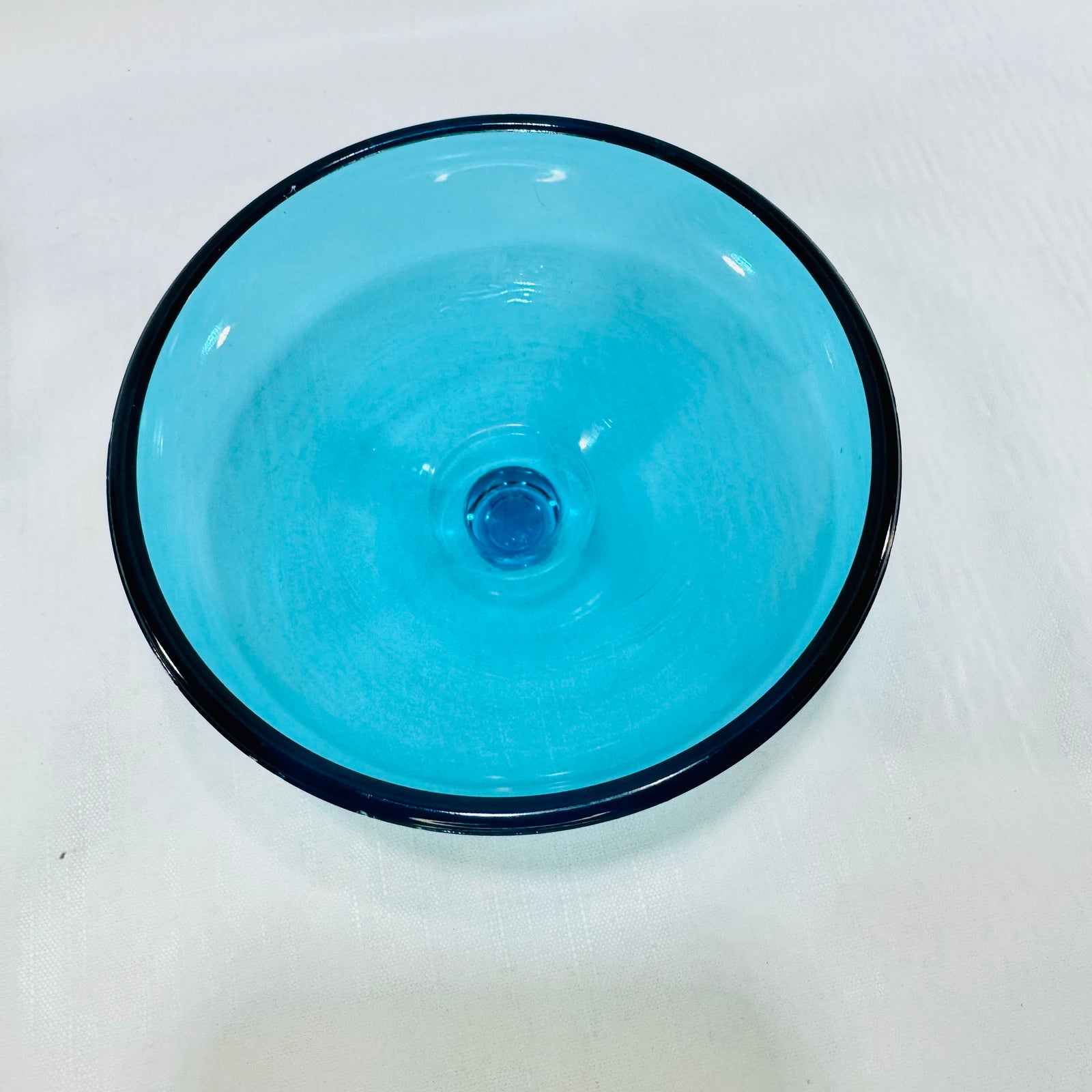 Top view of the round turquoise glass bobeche with its wide rim and center knob