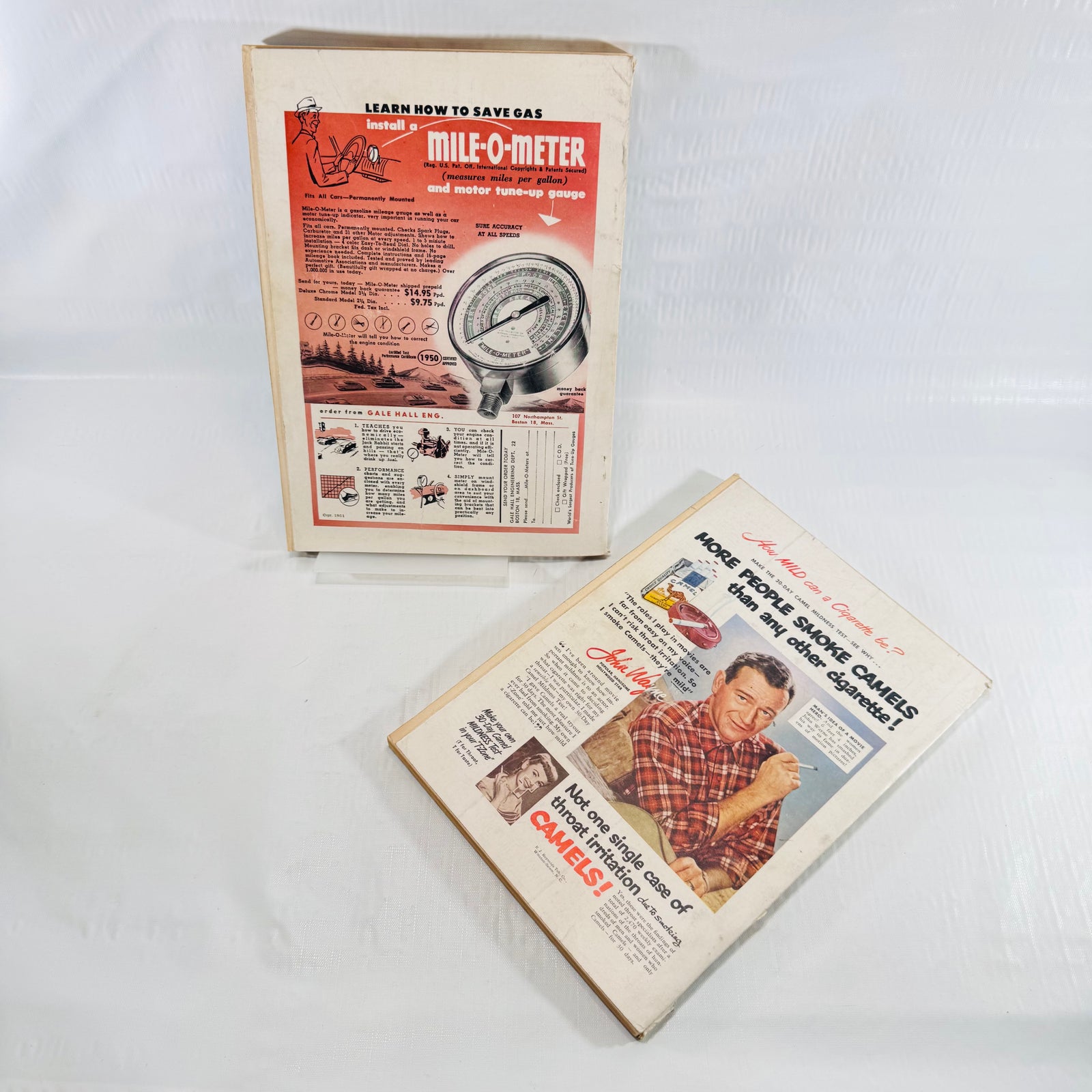 Back covers of both issues, Mile O Meter ad and John Wayne Camel cigarettes advertisement