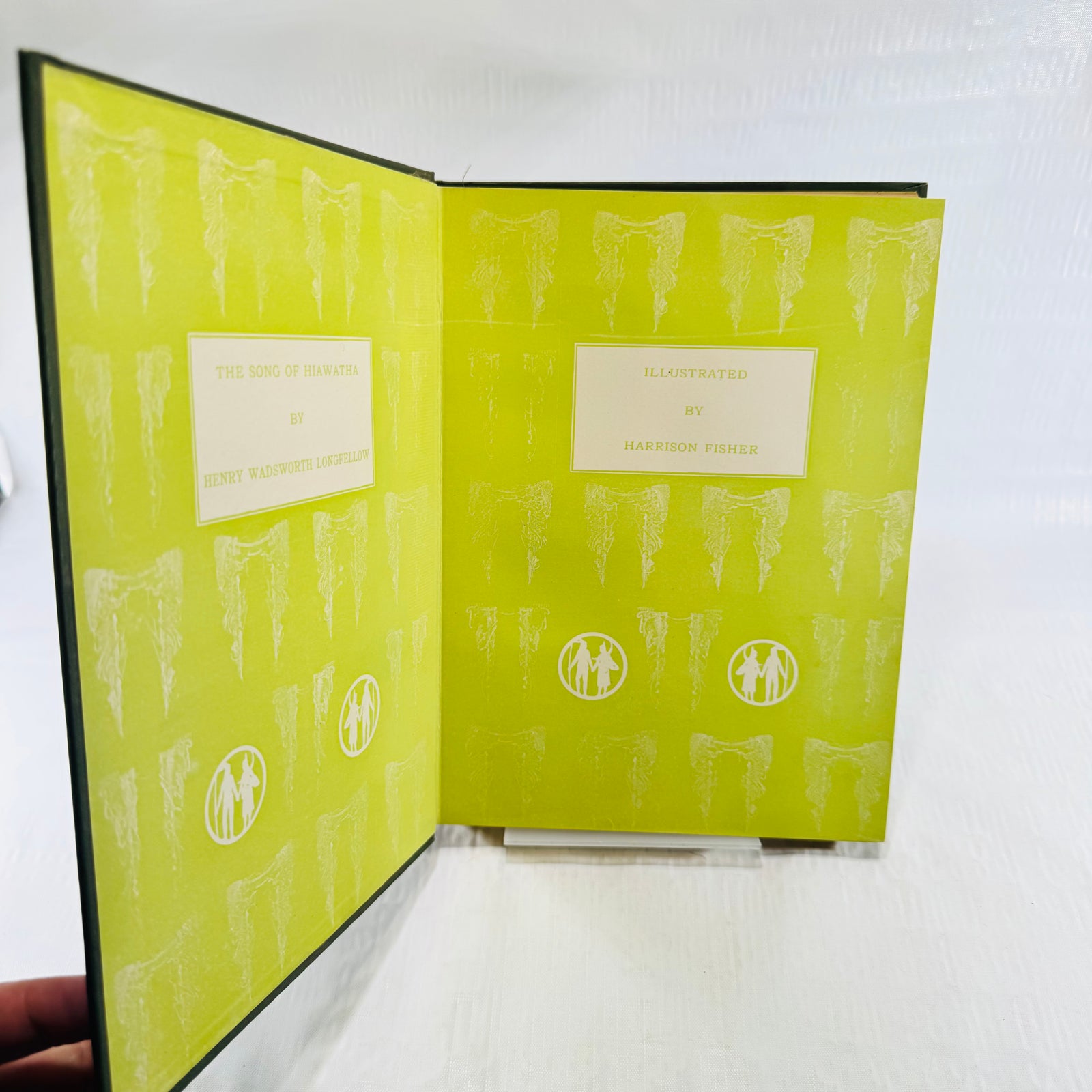 Green pictorial endpapers lettered The Song of Hiawatha by Longfellow, illustrated by Harrison Fisher