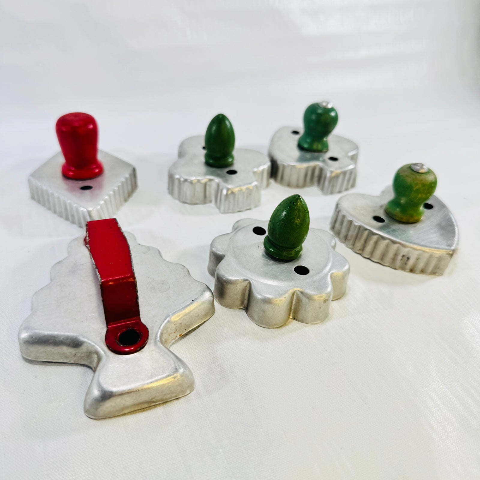 Angled view of the vintage red and green handled aluminum cookie cutter set