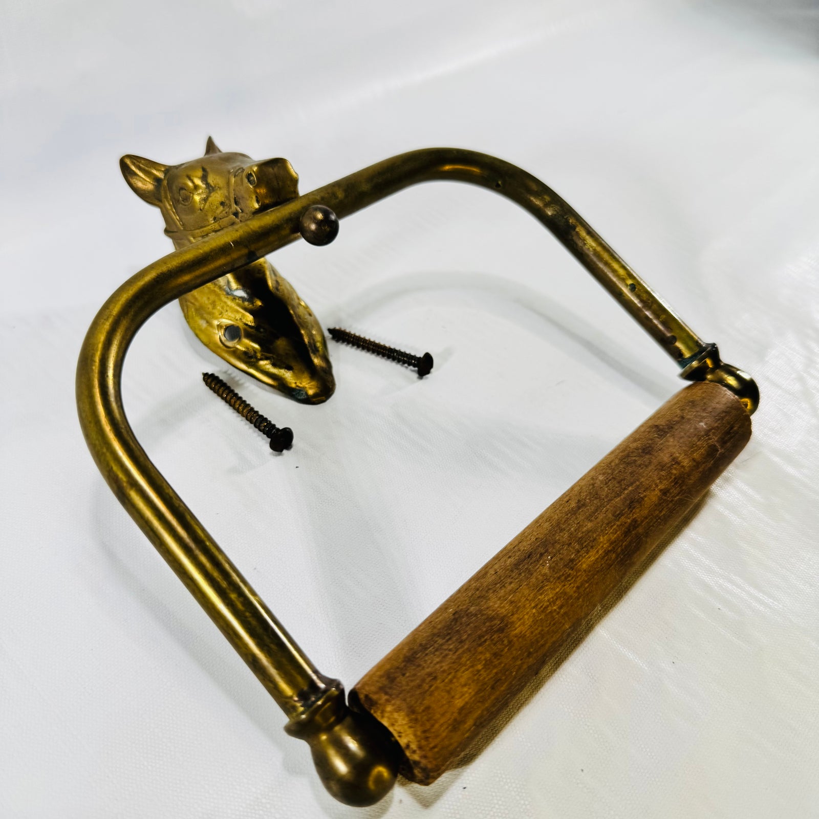 Angled view of the brass horse head tissue holder swing arm and hardwood roller