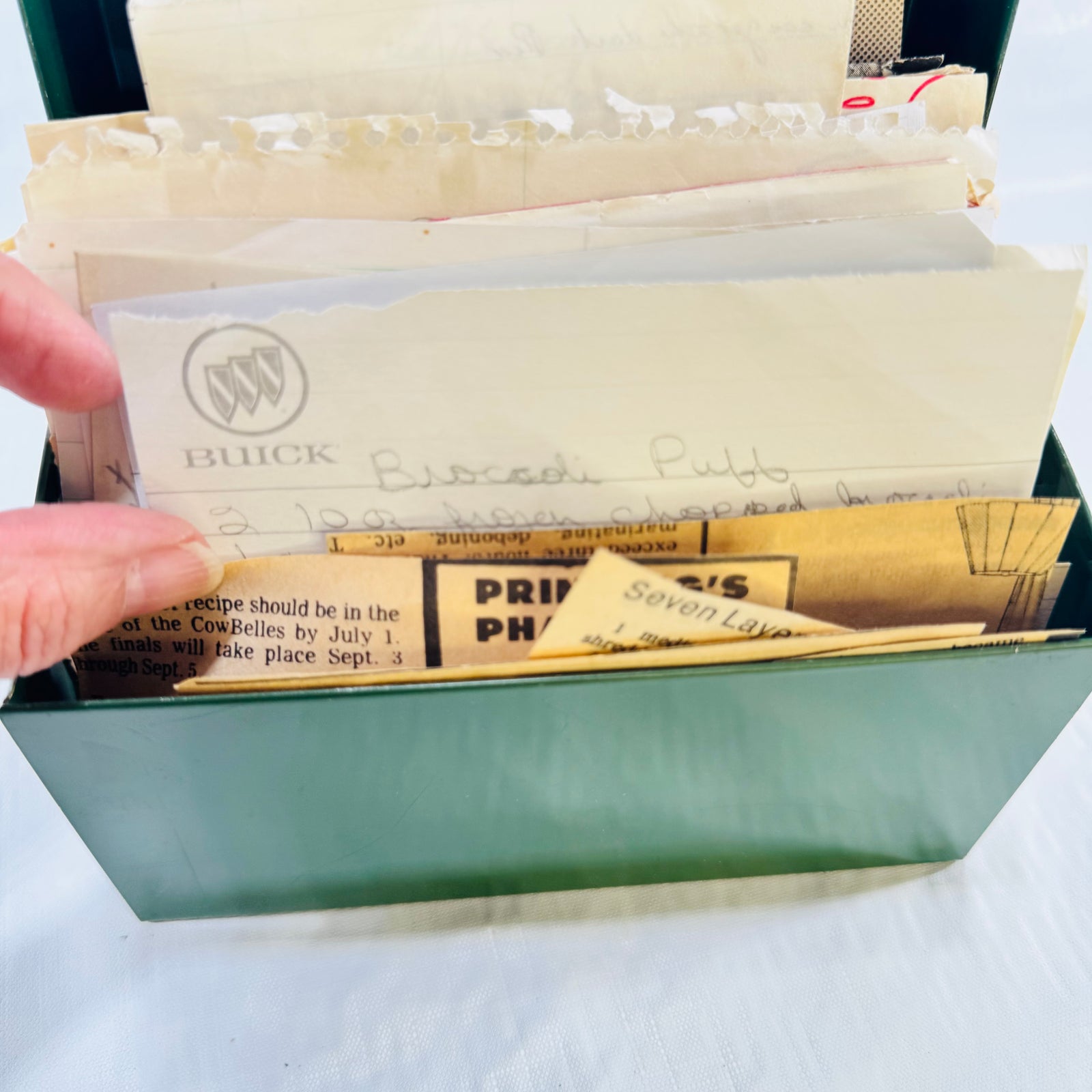 Close-up of handwritten recipe cards at the front of the green recipe box
