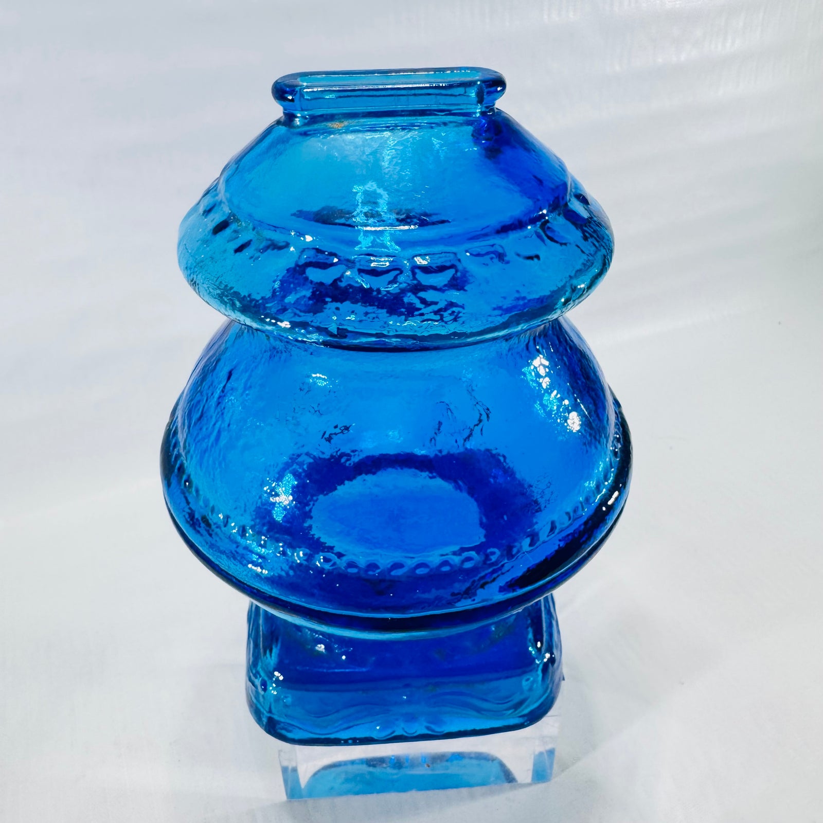 Back of the bright blue glass gumball machine bank with textured glass and beaded bands.