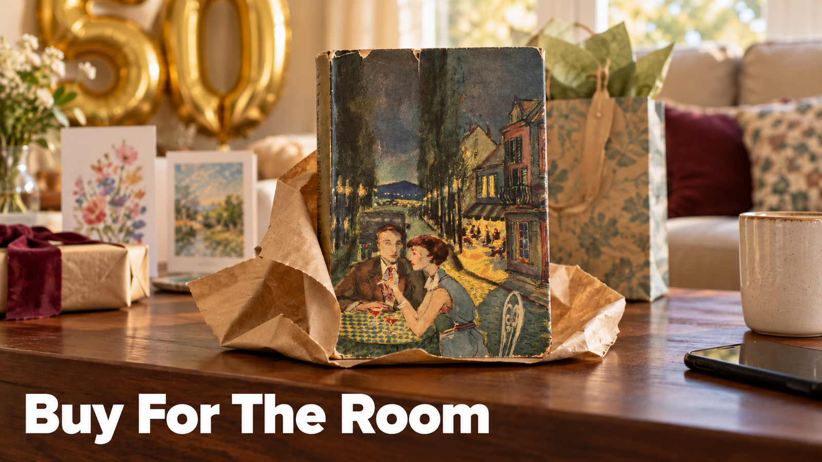 A wrapped vintage hardcover sitting on a milestone birthday gift table among balloons and joke cards, in a sunlit present day living room.