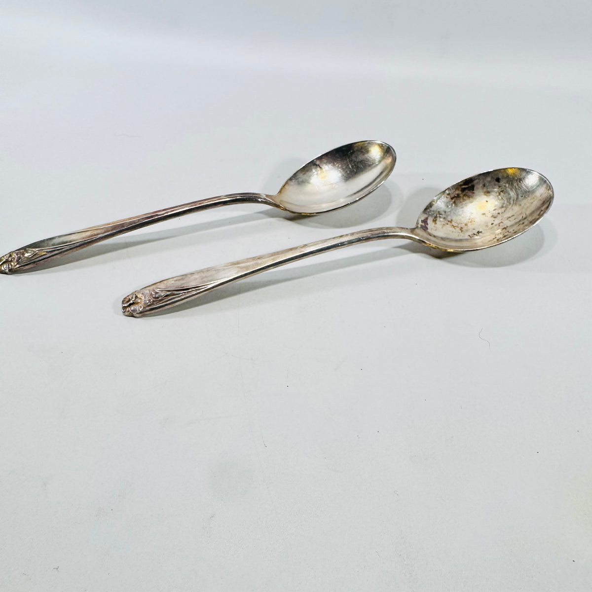 Side view of two 1847 Rogers Bros Daffodil silverplate soup spoons showing bowl depth