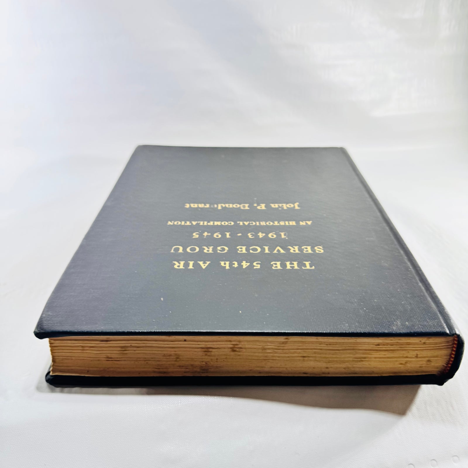 Angled cover view of the 54th Air Service Group book showing page edges