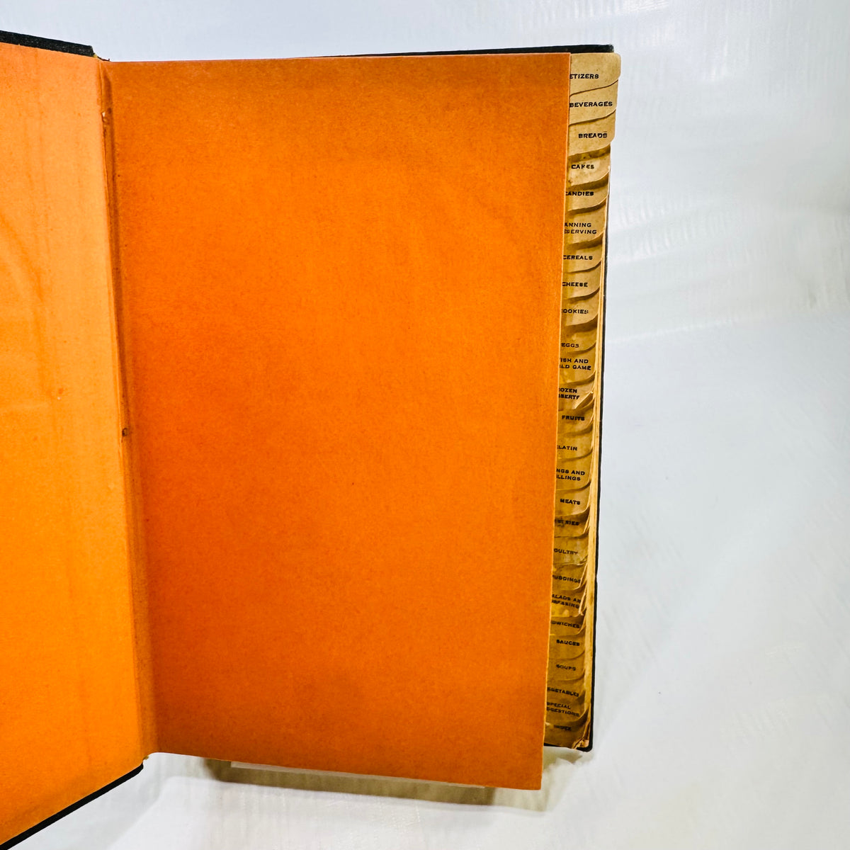 Orange endpaper and worn thumb index tabs