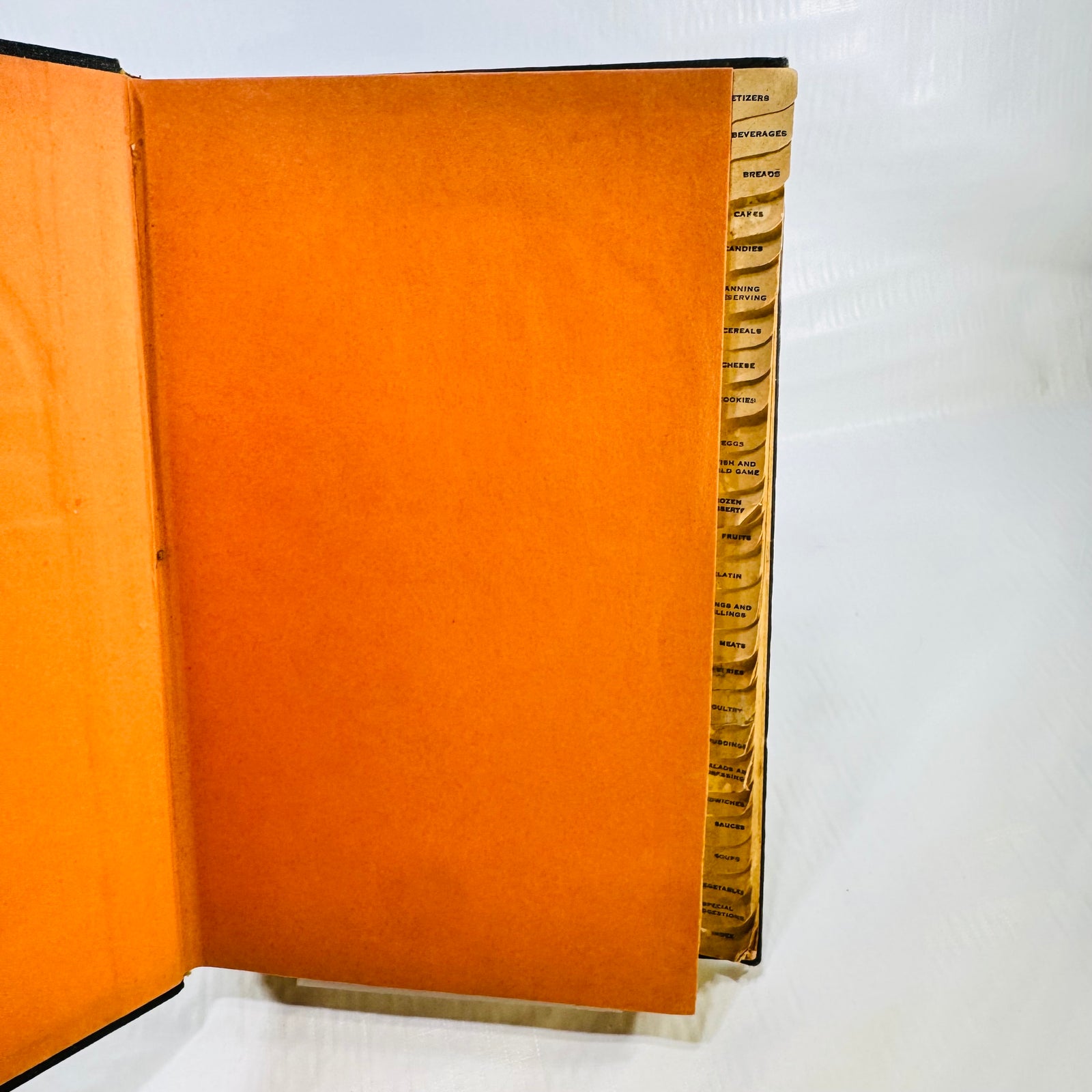 Orange endpaper and worn thumb index tabs