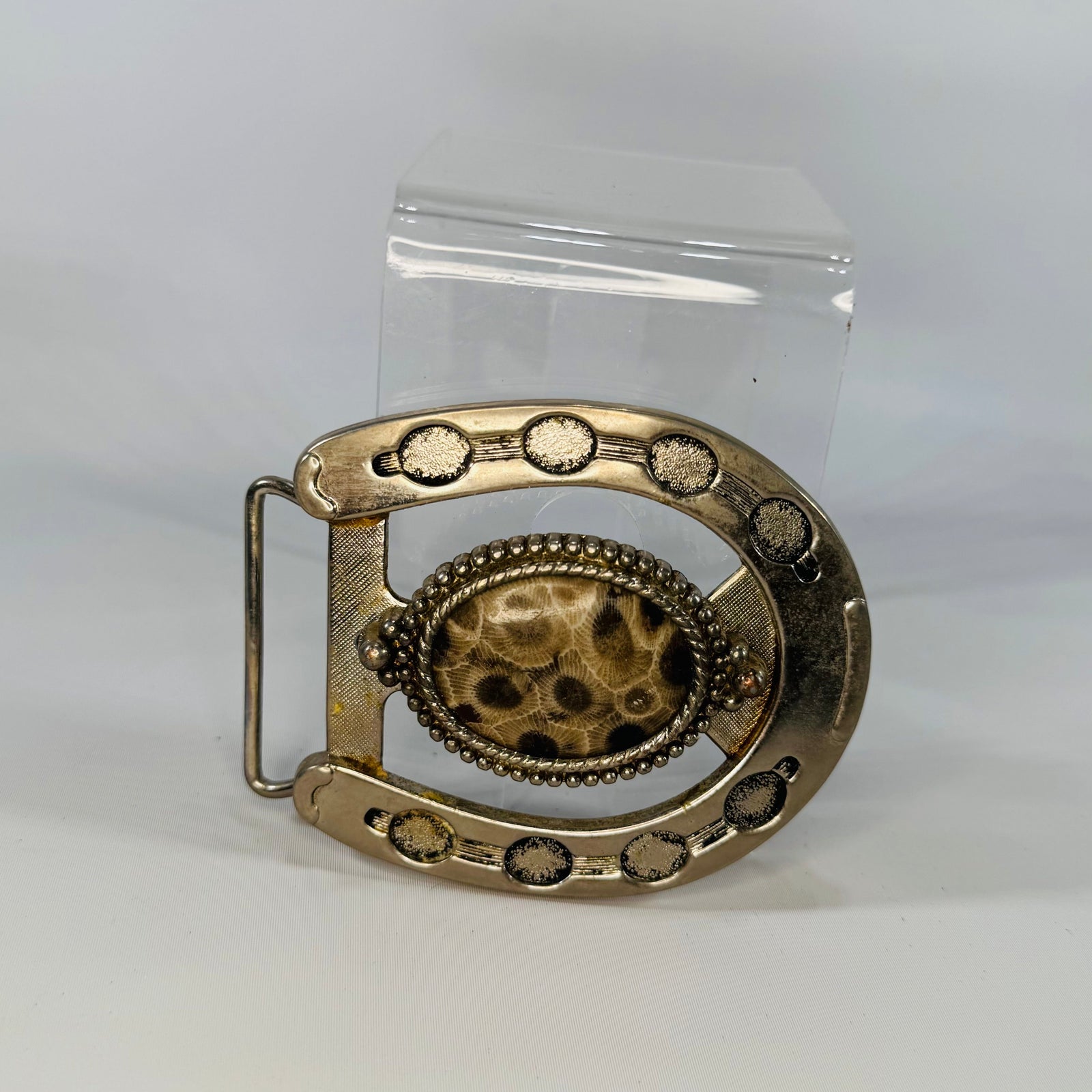 Decorative belt buckle with intricate design on a white background