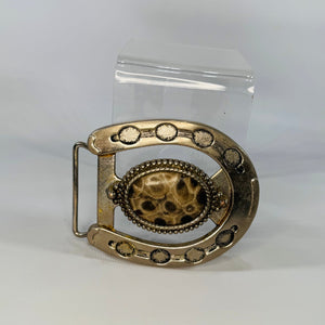 Decorative belt buckle with intricate design on a white background