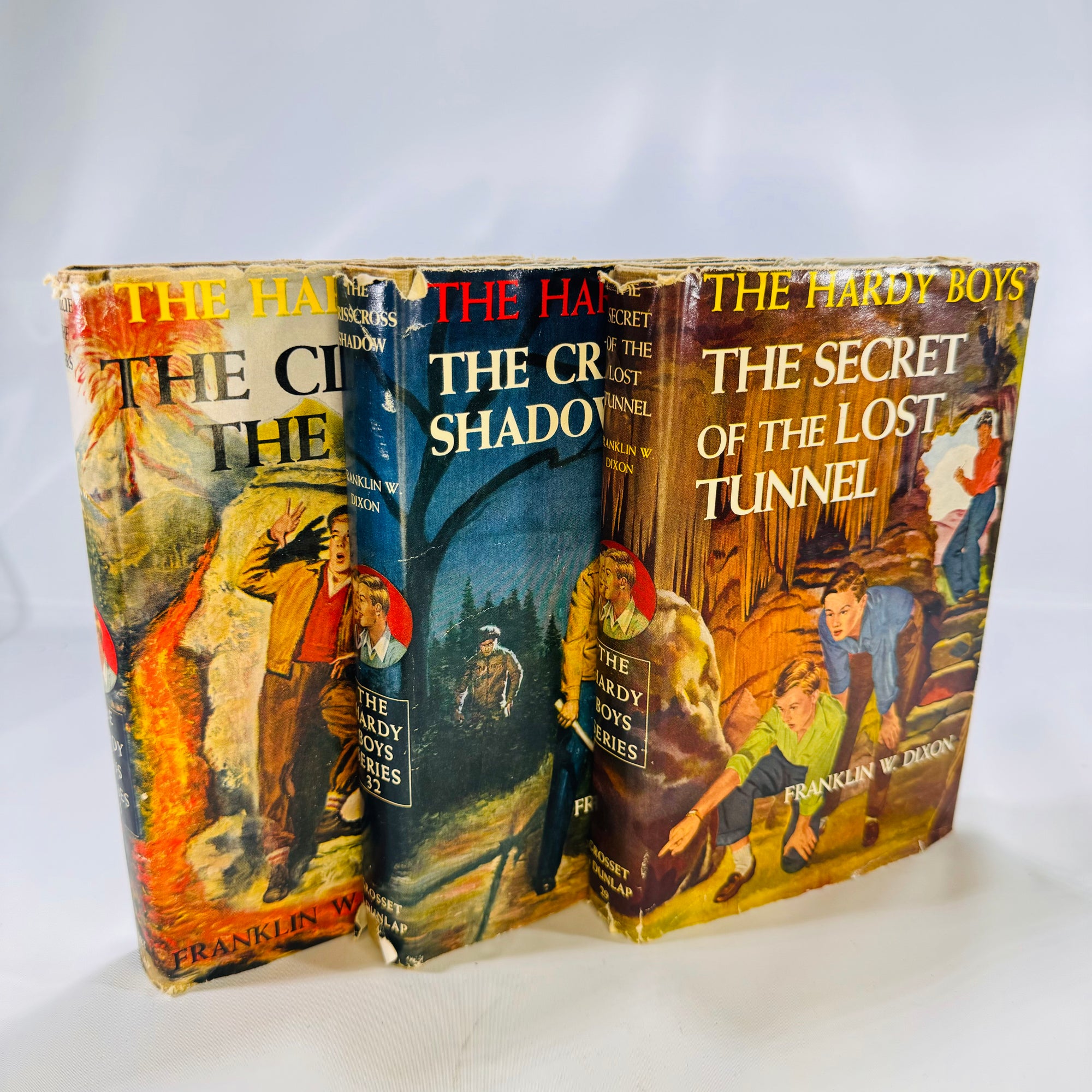 Three Hardy Boys Books by Franklin W. Dixon The Crisscross Shadow The Secret of the Lost Tunnel, The Clue in the Embers Grosset and Dunlap