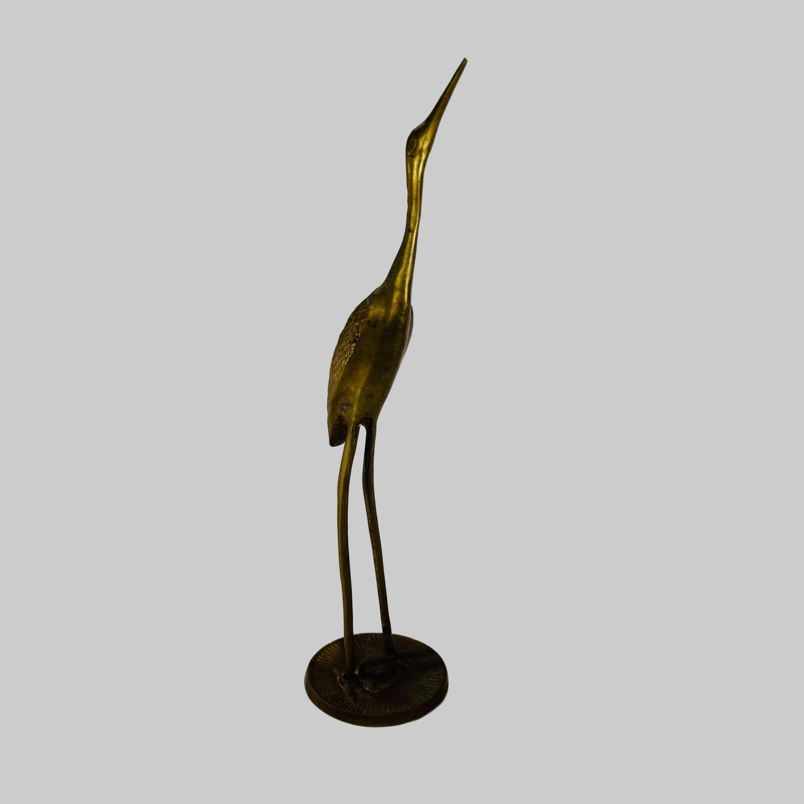 Bronze sculpture of a crane on a white background