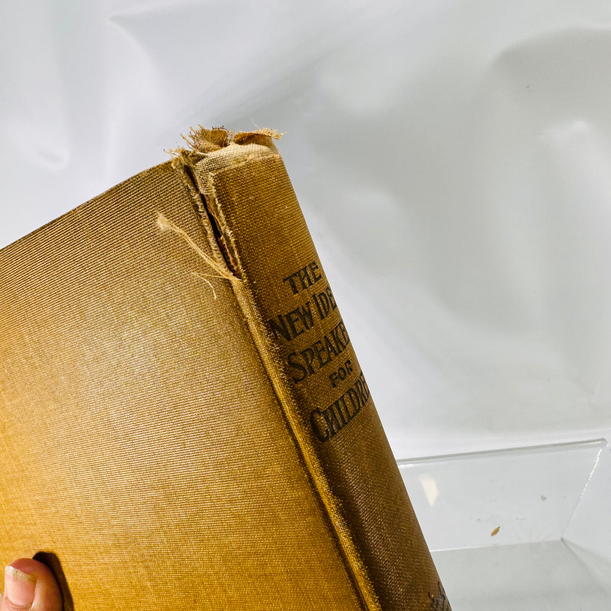 Close-up of the frayed spine head and cloth split, New Idea Speaker 1902