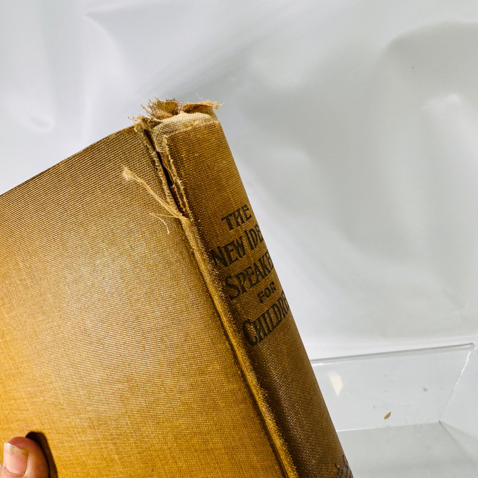 Close-up of the frayed spine head and cloth split, New Idea Speaker 1902