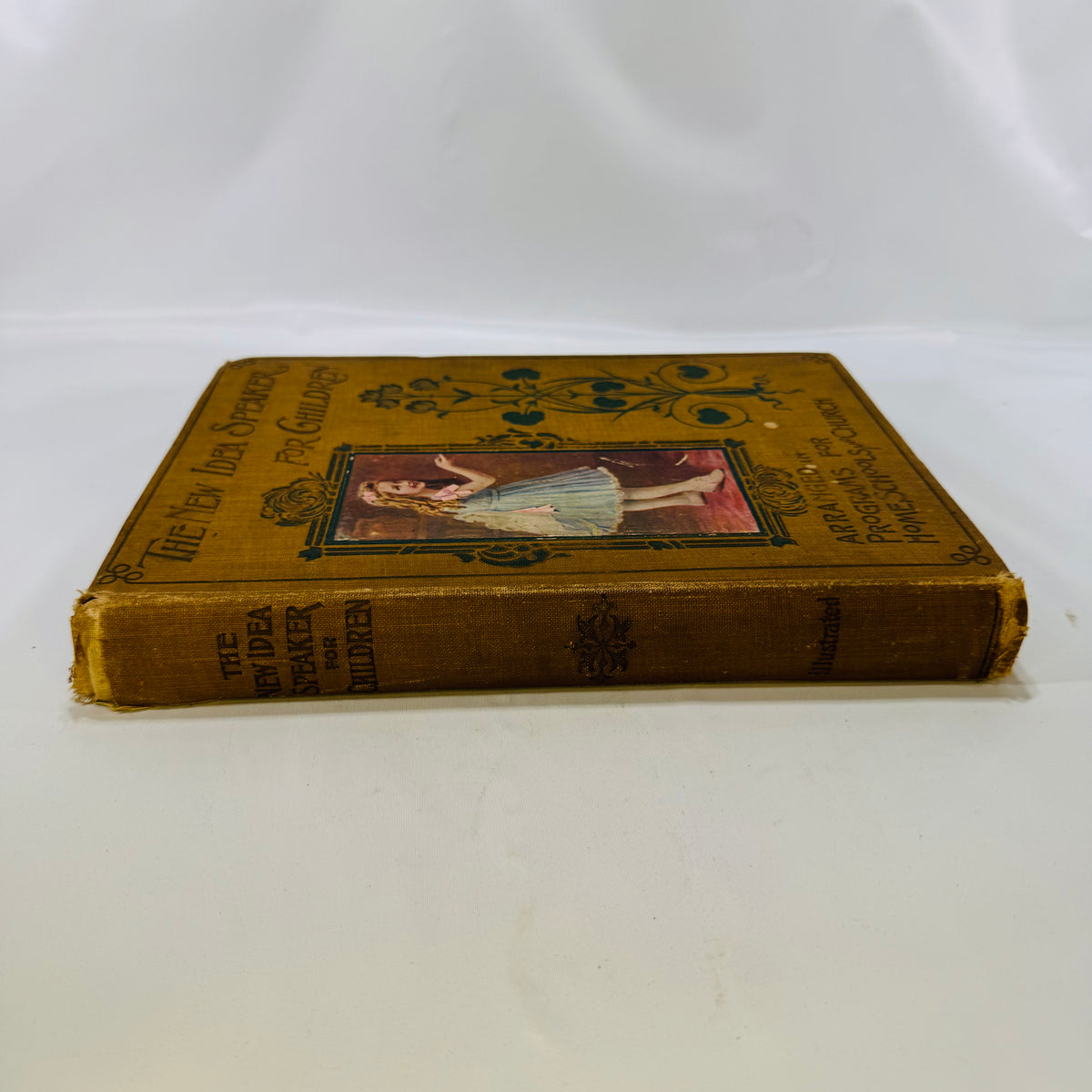 Spine of The New Idea Speaker for Children 1902 with worn cloth