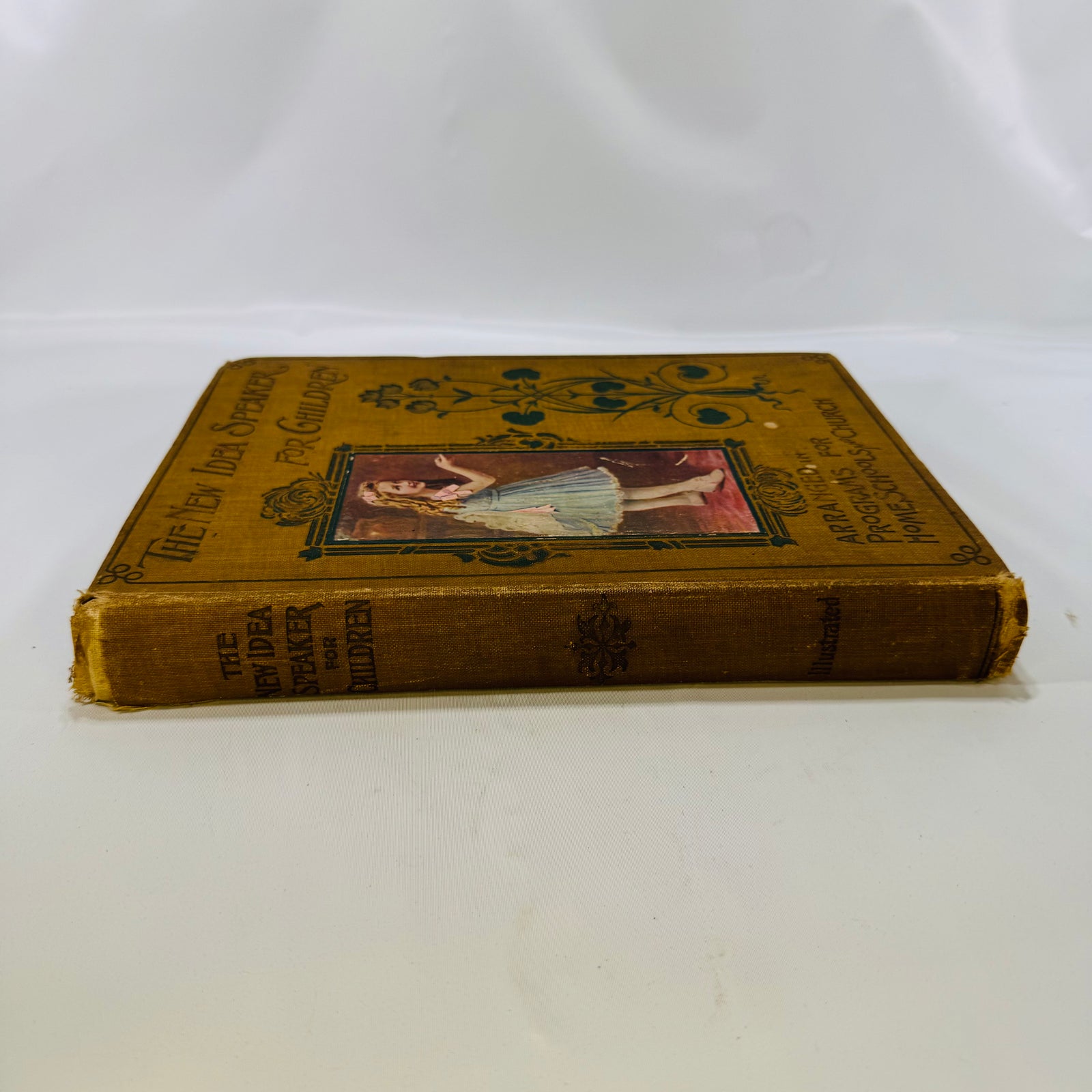 Spine of The New Idea Speaker for Children 1902 with worn cloth