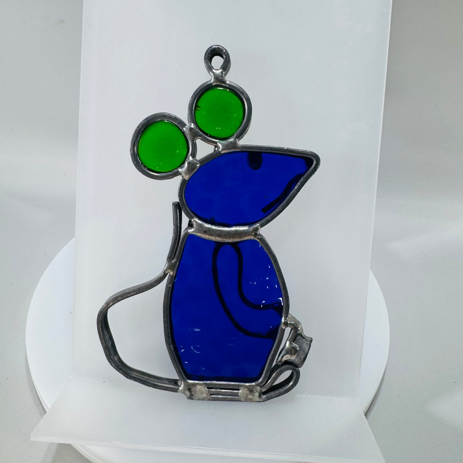 Blue and green stained glass mouse suncatcher with silver-tone soldered outline and hanging loop, shown from front, side, and laying flat.