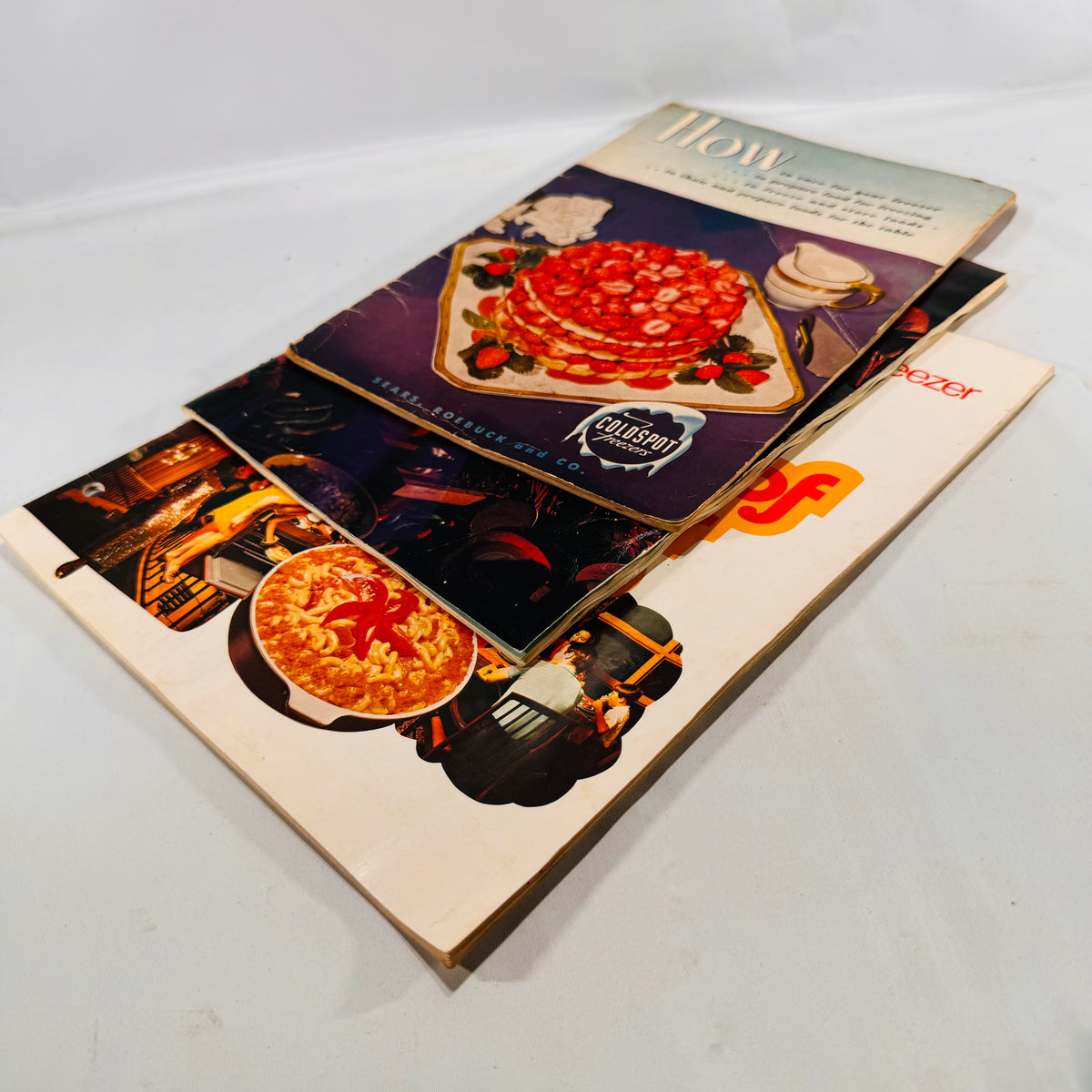 Three Sears Coldspot freezer manuals lying at an angle