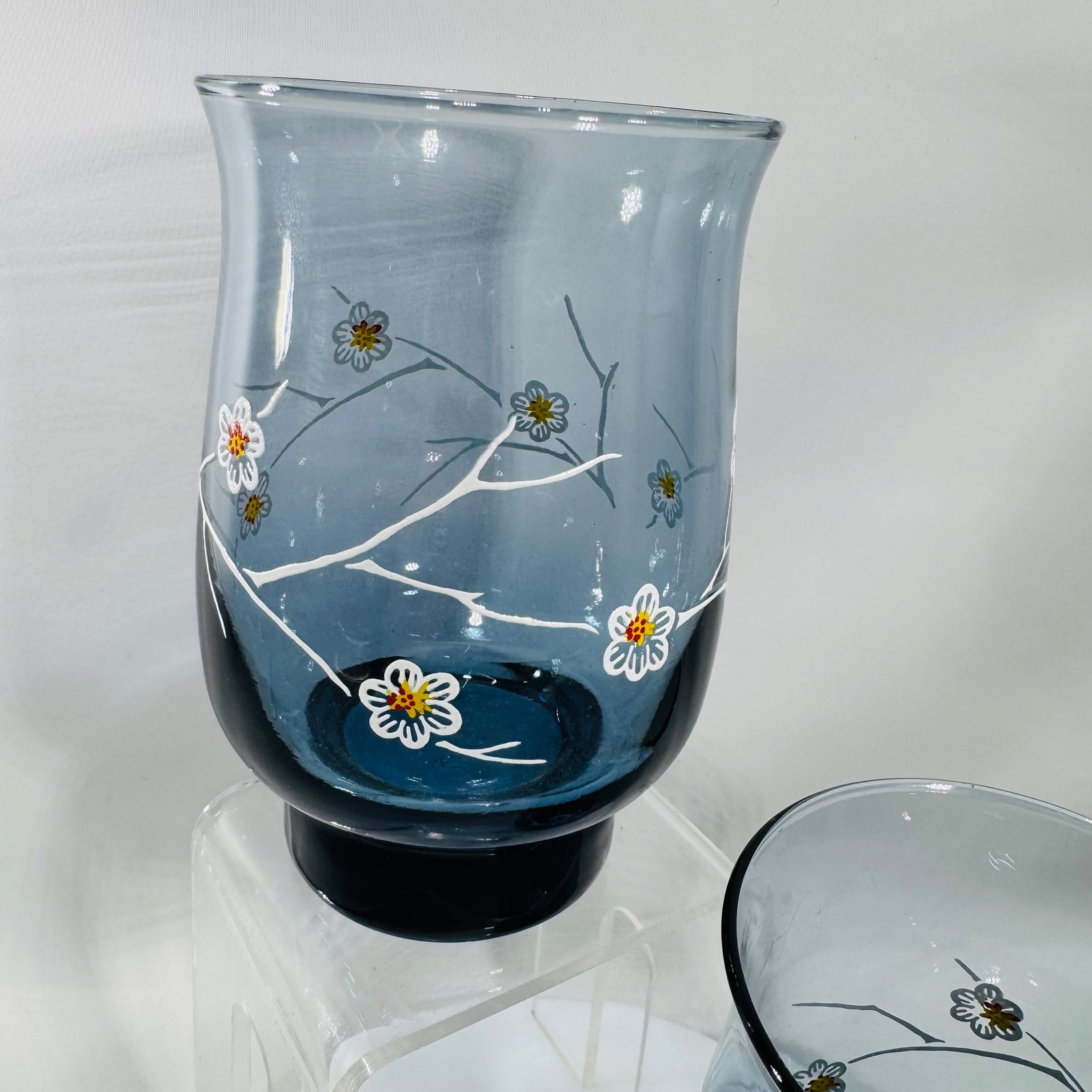 Two vintage Libbey smoky blue dogwood tumblers with white branch and floral design, 5 inches tall with darker blue weighted base.
