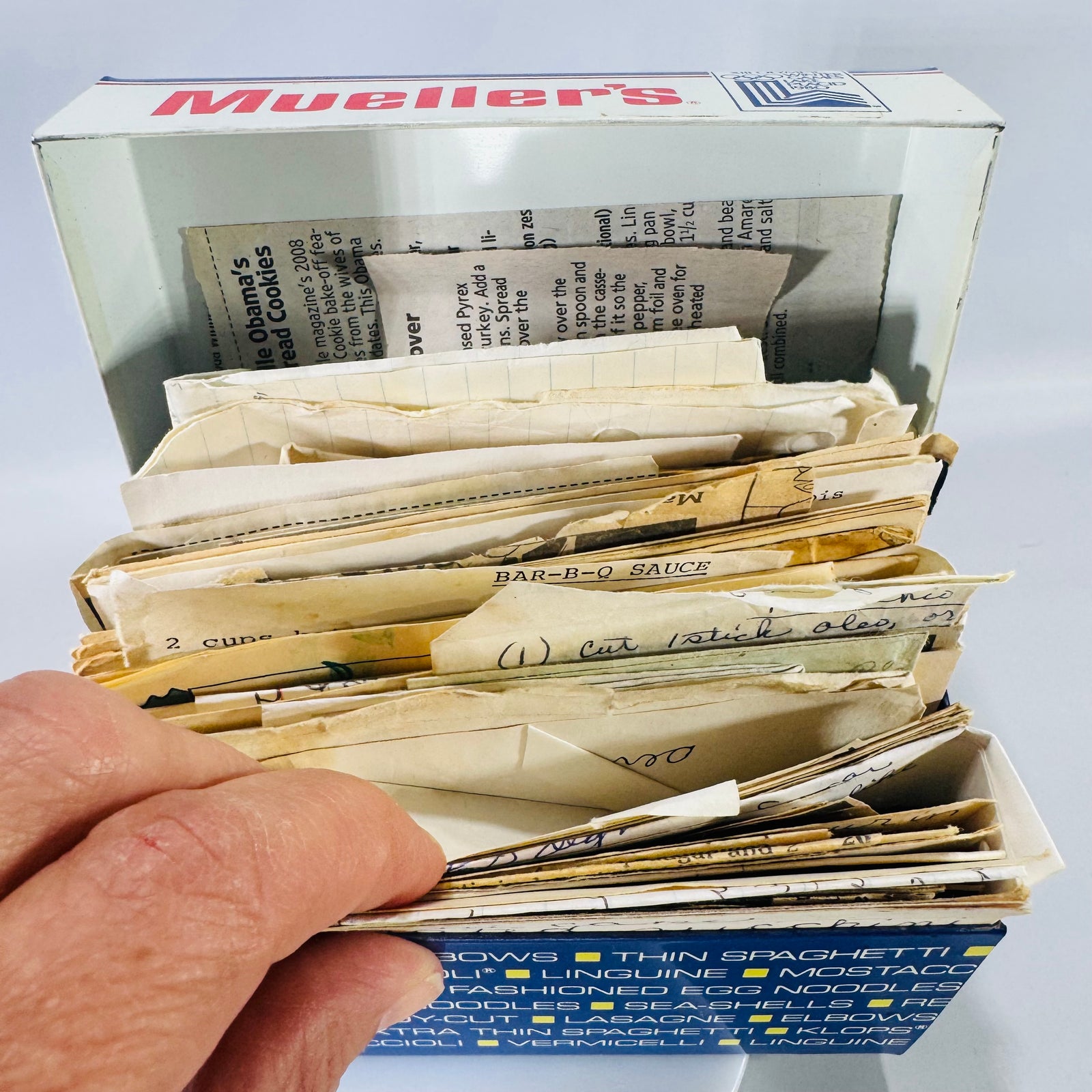 Mueller’s vintage recipe box filled with handwritten recipe cards and newspaper and magazine clippings, Lake Placid 1980 Olympics logo on lid.