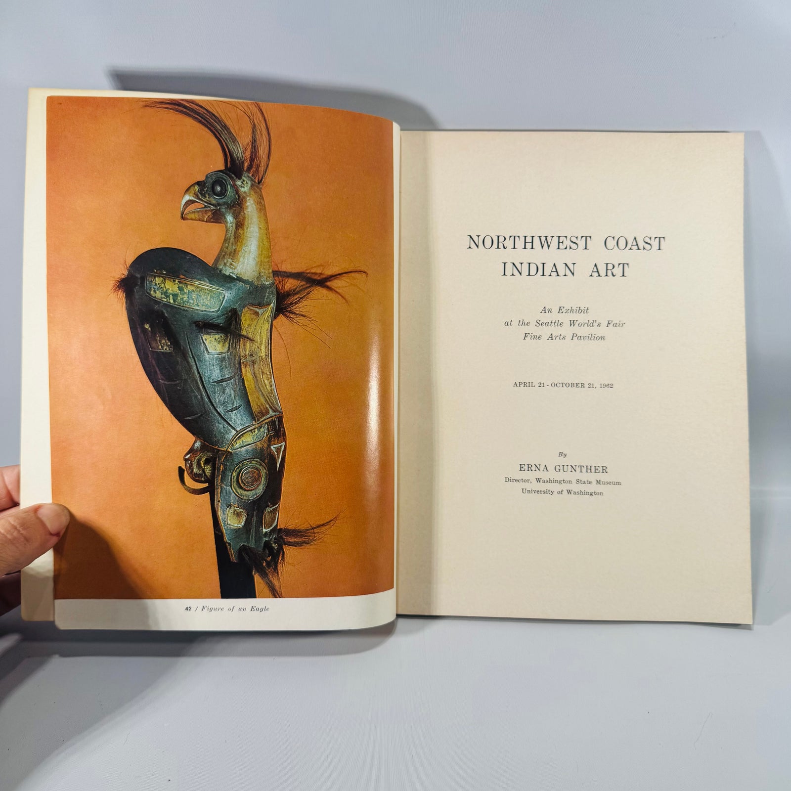 1962 Seattle World’s Fair paperback catalog “Northwest Coast Indian Art” with bold red, blue, and black graphic cover; visible shelfwear to edges.