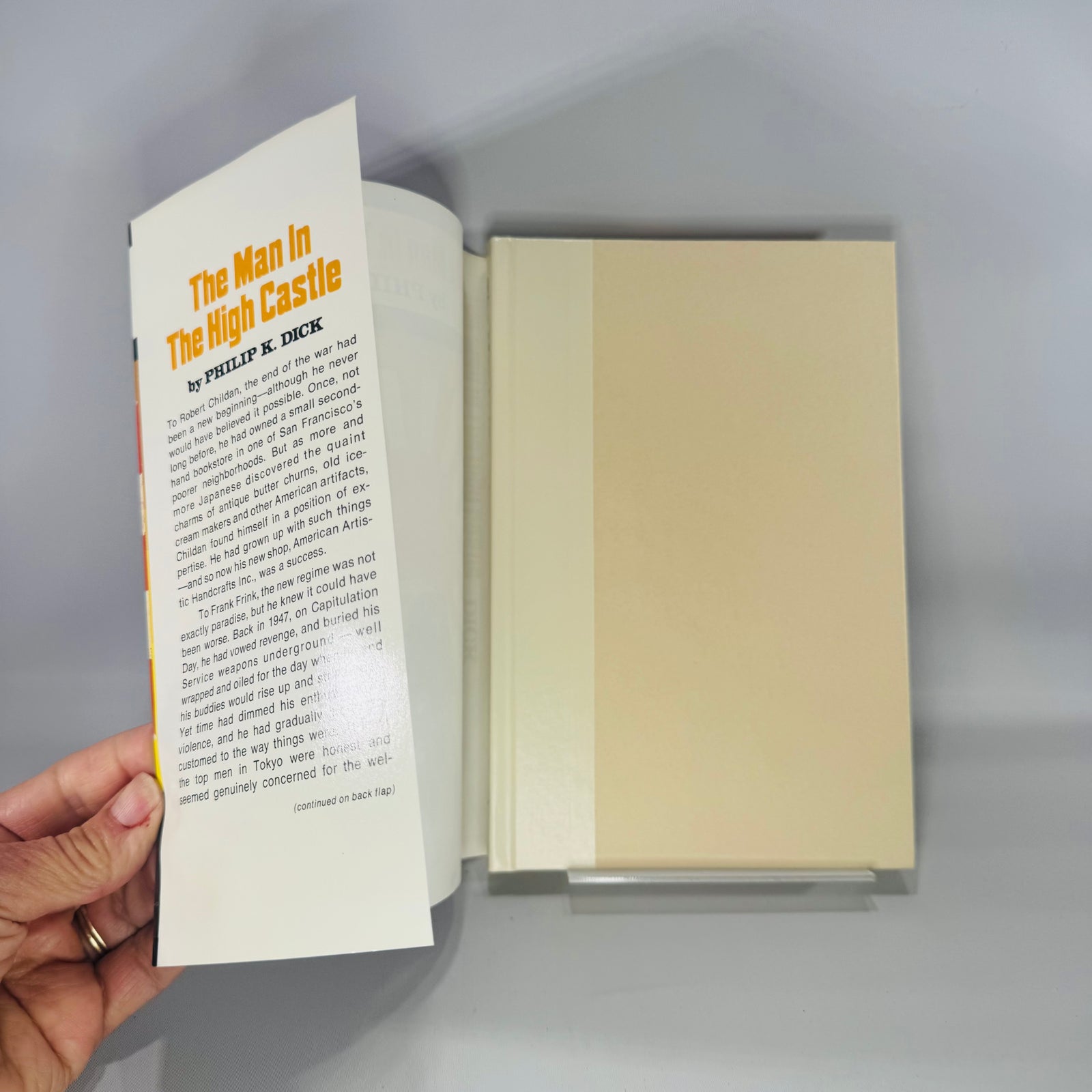 Front cover of The Man in the High Castle by Philip K. Dick, vintage dust jacket with rising sun rays artwork.