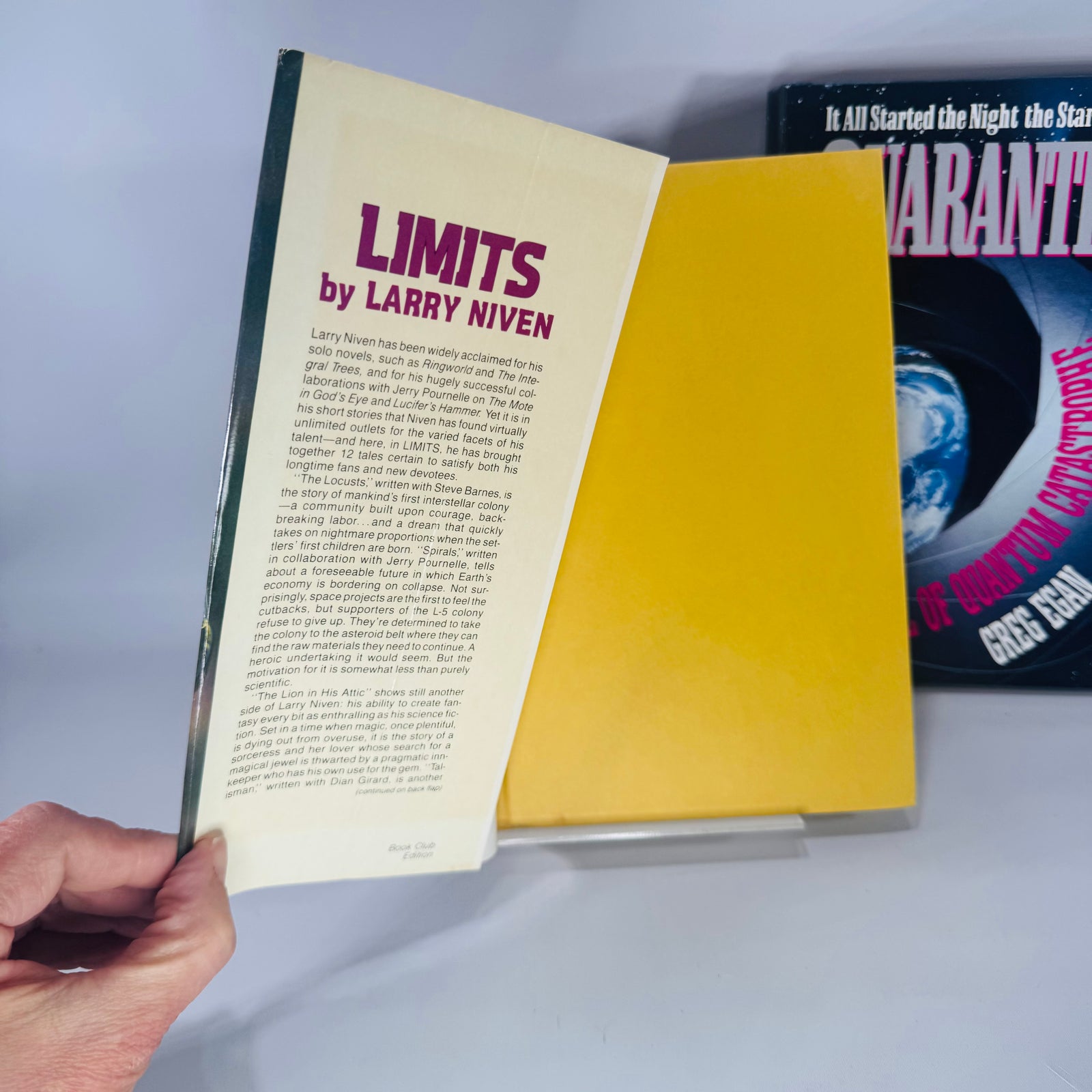 Two vintage science fiction hardcovers side by side—Limits by Larry Niven and Quarantine by Greg Egan—with colorful dust jackets and clean, bright interiors shown.