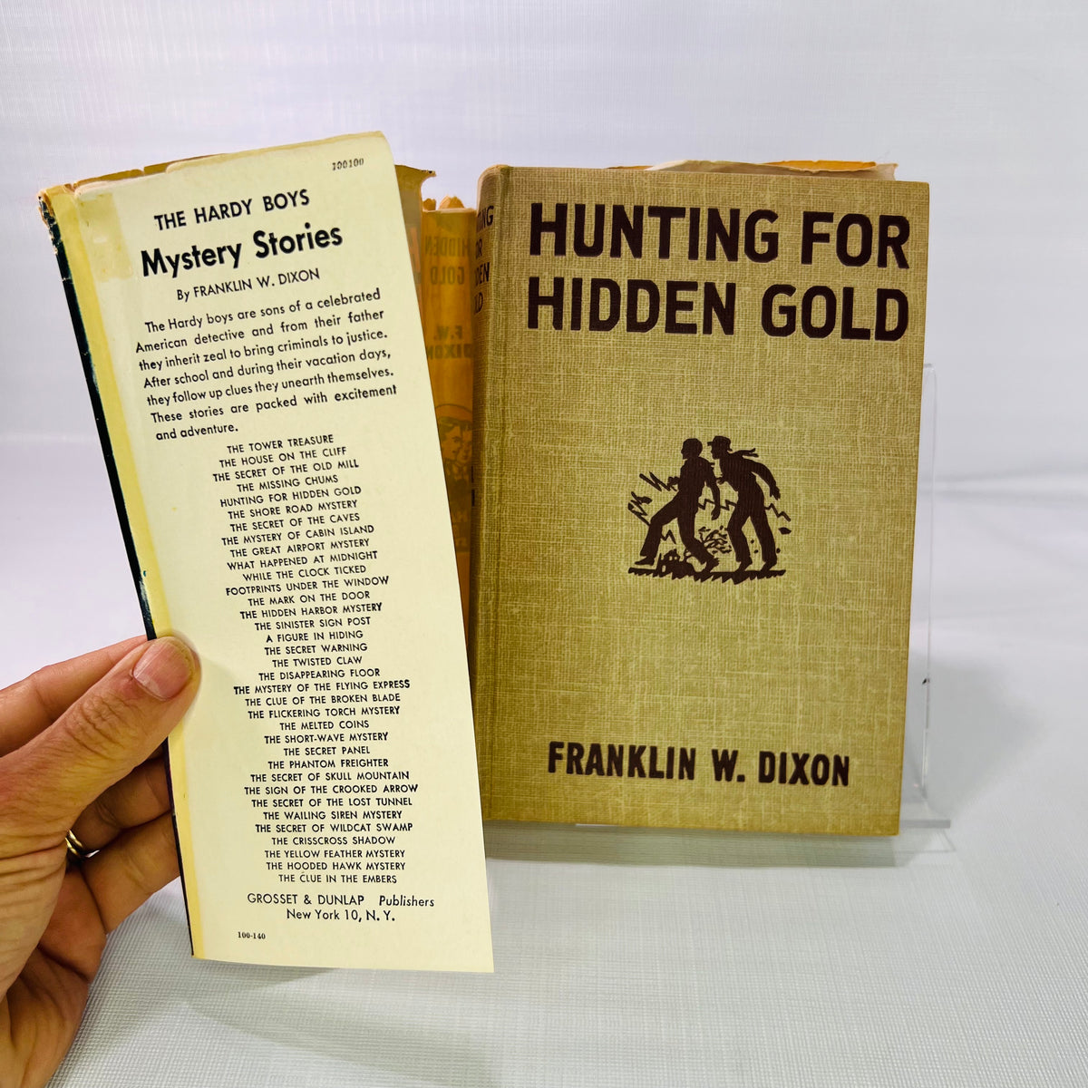 Jacket flap listing Hardy Boys Mystery Stories beside the tan cloth cover, Hunting for Hidden Gold