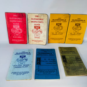 Seven vintage Oldsmobile Inspector’s Guide booklets (1981–1983) in mixed cover colors, stacked and laid out—shop-worn Lansing Plant 88–98 and Cutlass series references.