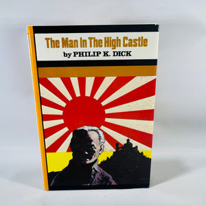 Front cover of The Man in the High Castle by Philip K. Dick, vintage dust jacket with rising sun rays artwork.