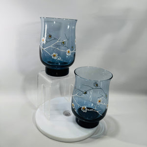 Two vintage Libbey smoky blue dogwood tumblers with white branch and floral design, 5 inches tall with darker blue weighted base.