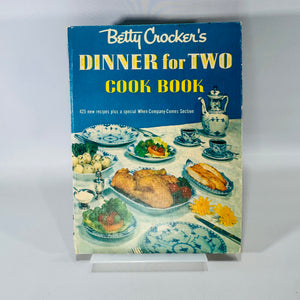 Vintage 1958 Betty Crocker Dinner for Two Cook Book with blue cover, ring binding, Charles Harper illustrated pages, and tucked-in handwritten recipe cards.