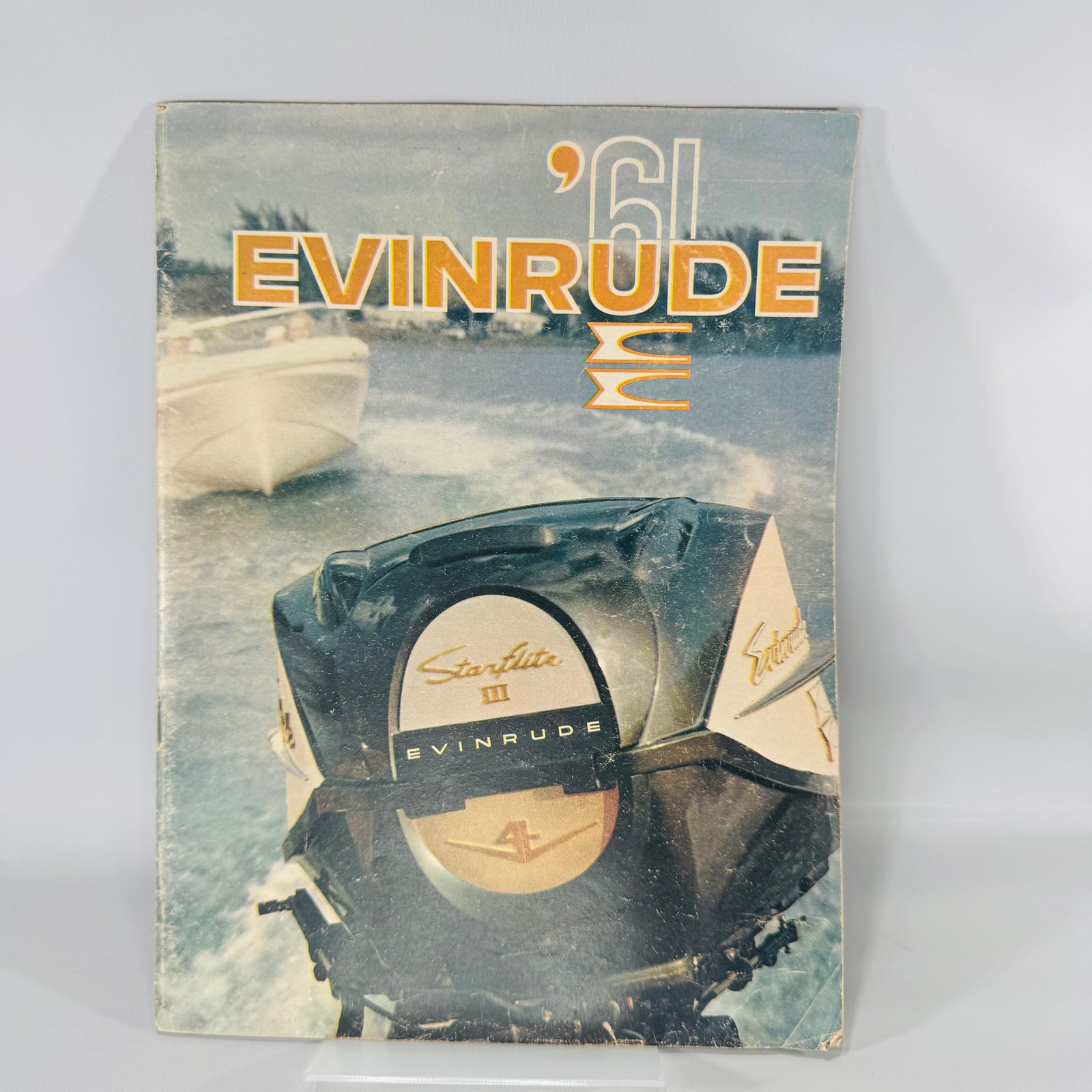 Vintage ’61 Evinrude outboard motor brochure with worn glossy cover showing an Evinrude engine on the water; 23-page midcentury boating advertising ephemera.
