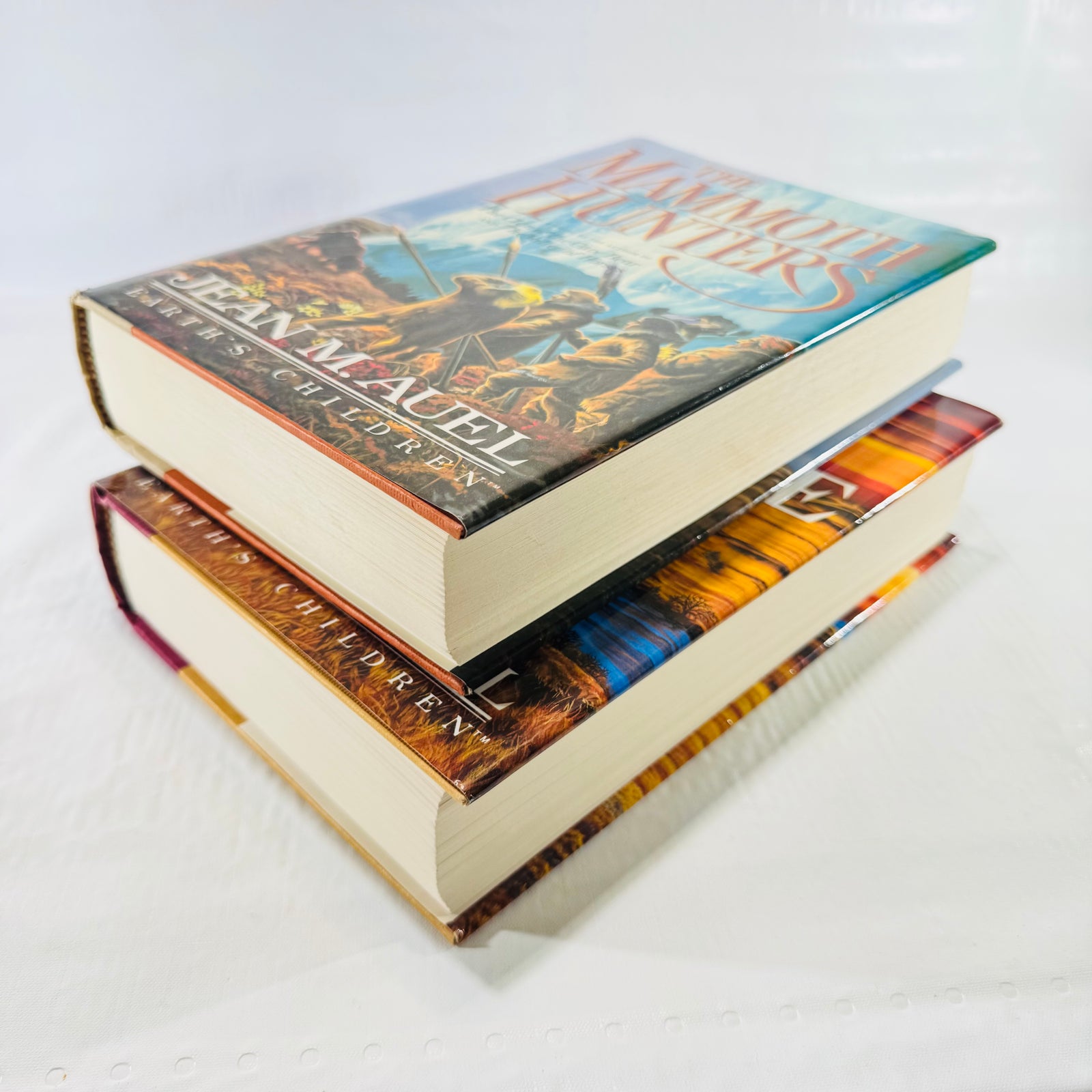 Two books stacked with The Mammoth Hunters resting on top