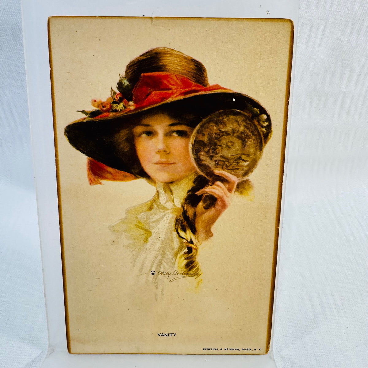 Vanity postcard by Philip Boileau showing a woman with a wide hat and hand mirror