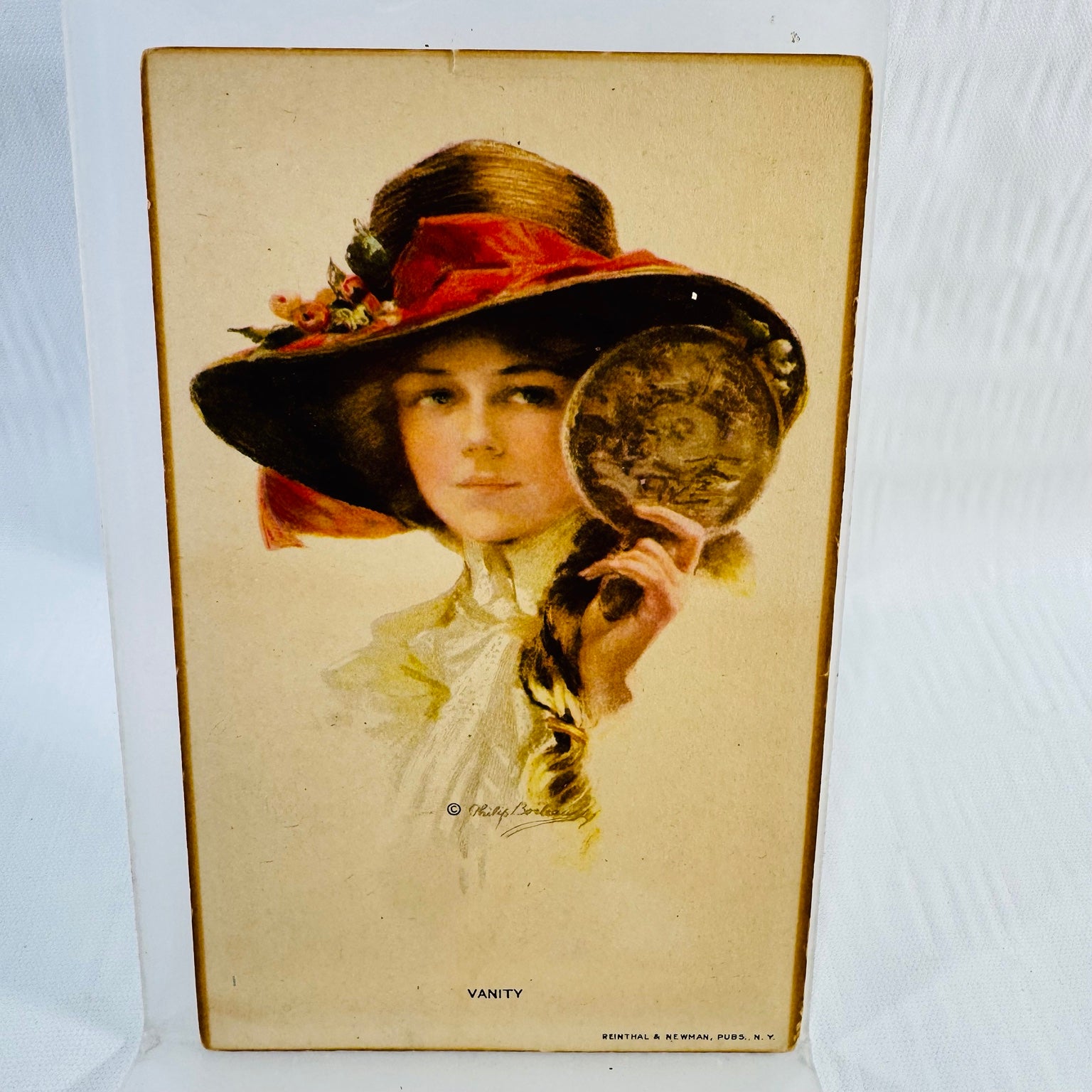 Vanity postcard by Philip Boileau showing a woman with a wide hat and hand mirror