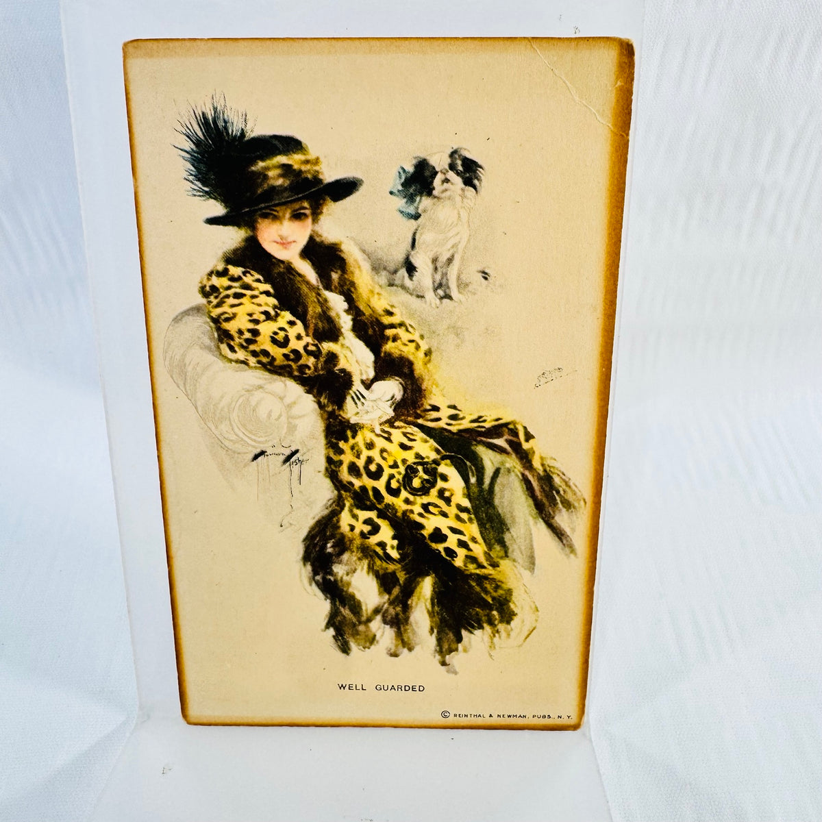 Well Guarded postcard by Harrison Fisher showing a woman and dog with upper right corner crease